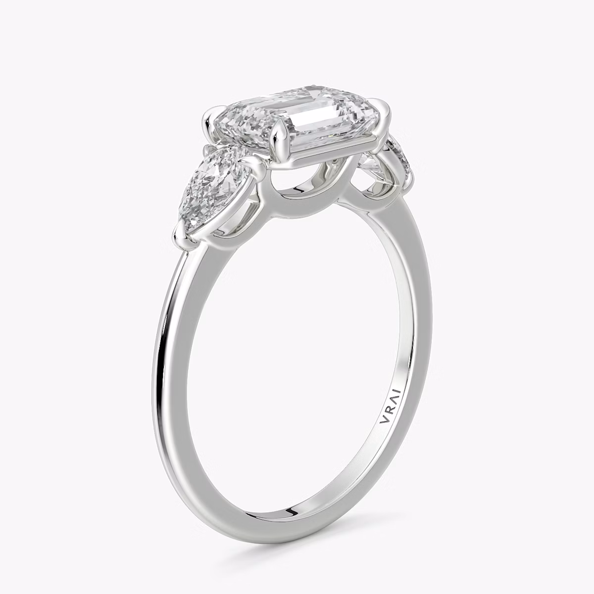 The Three Stone | Emerald | 18k | White Gold | bandAccent: Plain | diamondOrientation: horizontal | sideStoneCarat: 0.25ct | sideStoneShape: Pear | caratWeight: other