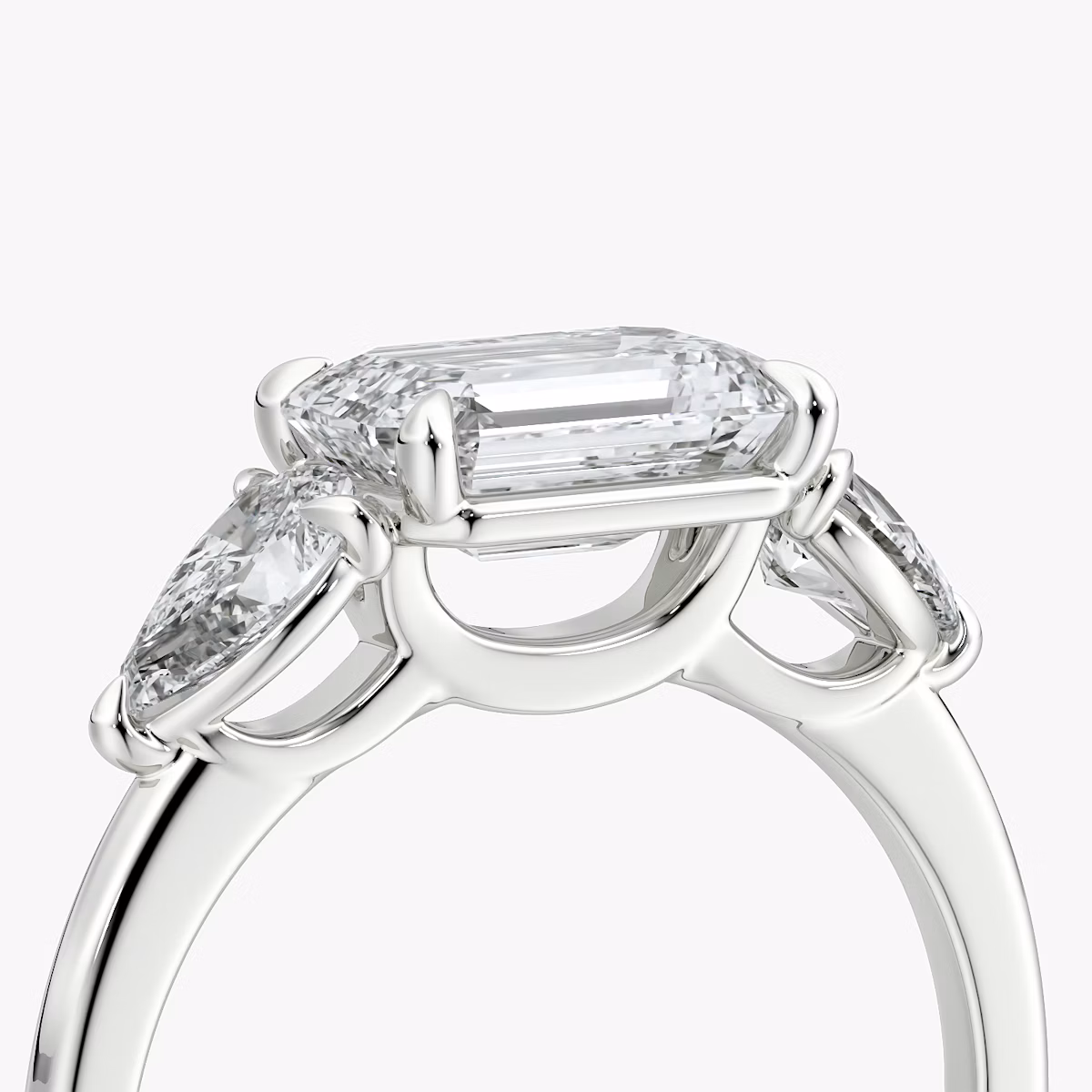 The Three Stone | Emerald | 18k | White Gold | bandAccent: Plain | diamondOrientation: horizontal | sideStoneCarat: 0.25ct | sideStoneShape: Pear | caratWeight: other