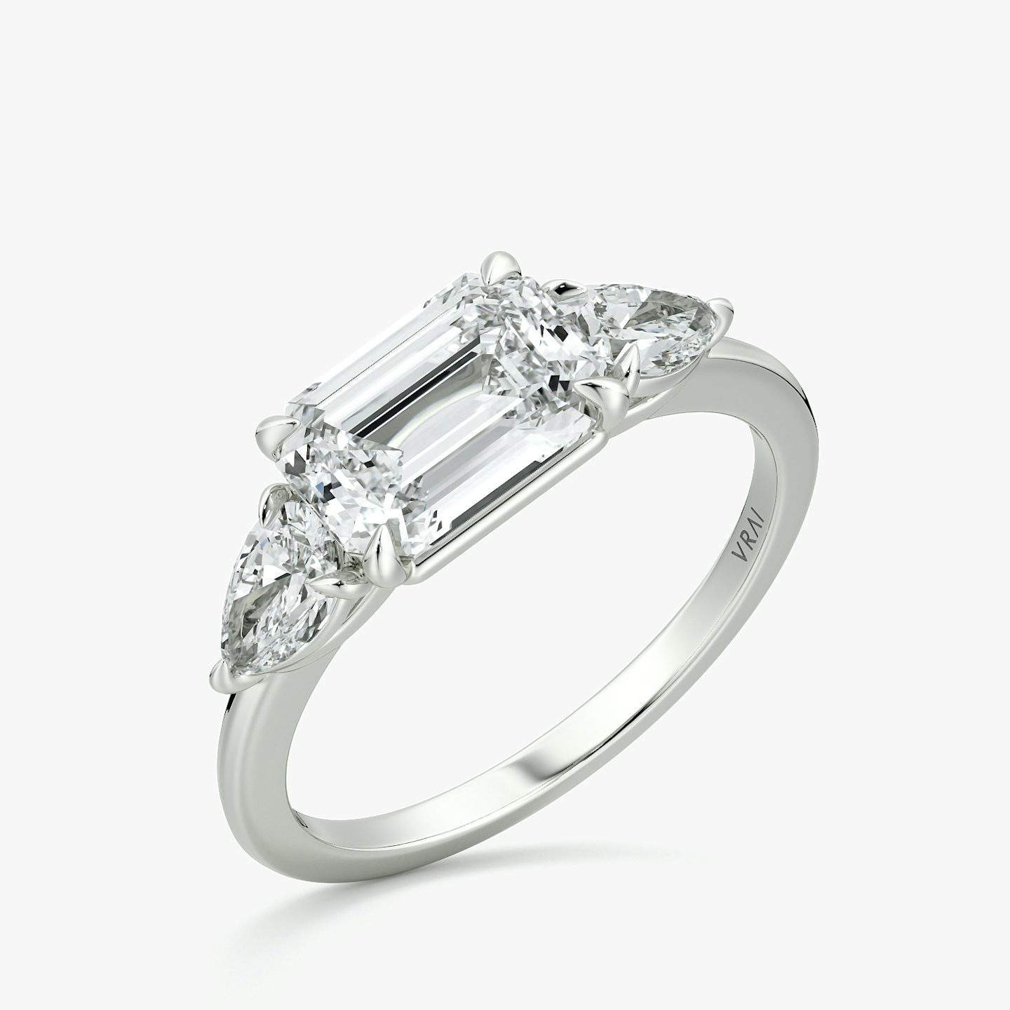 The Three Stone | Emerald | 18k | White Gold | bandAccent: Plain | diamondOrientation: horizontal | sideStoneCarat: 0.25ct | sideStoneShape: Pear | caratWeight: other