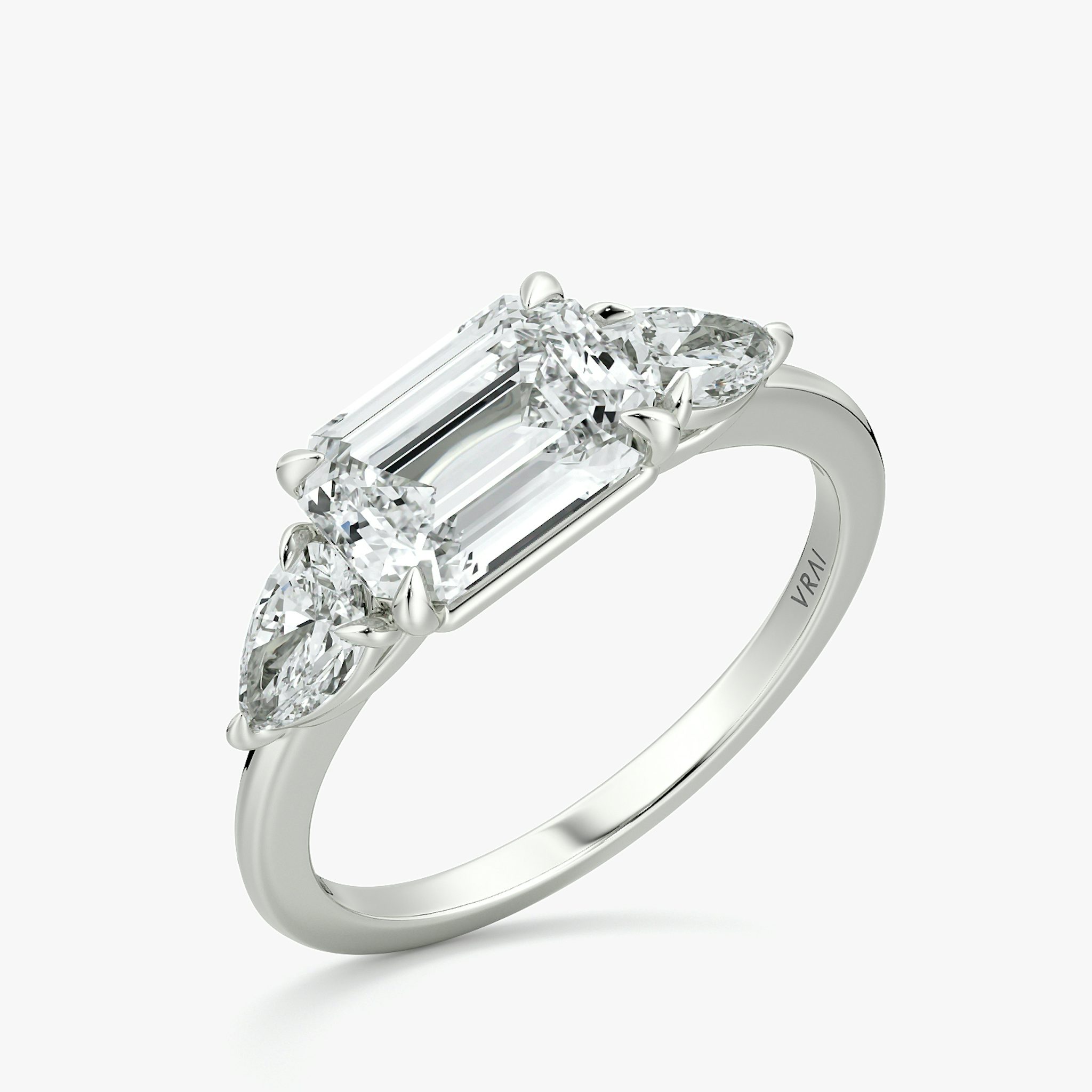 The Three Stone | Emerald | 18k | White Gold | bandAccent: Plain | diamondOrientation: horizontal | sideStoneCarat: 0.25ct | sideStoneShape: Pear | caratWeight: other