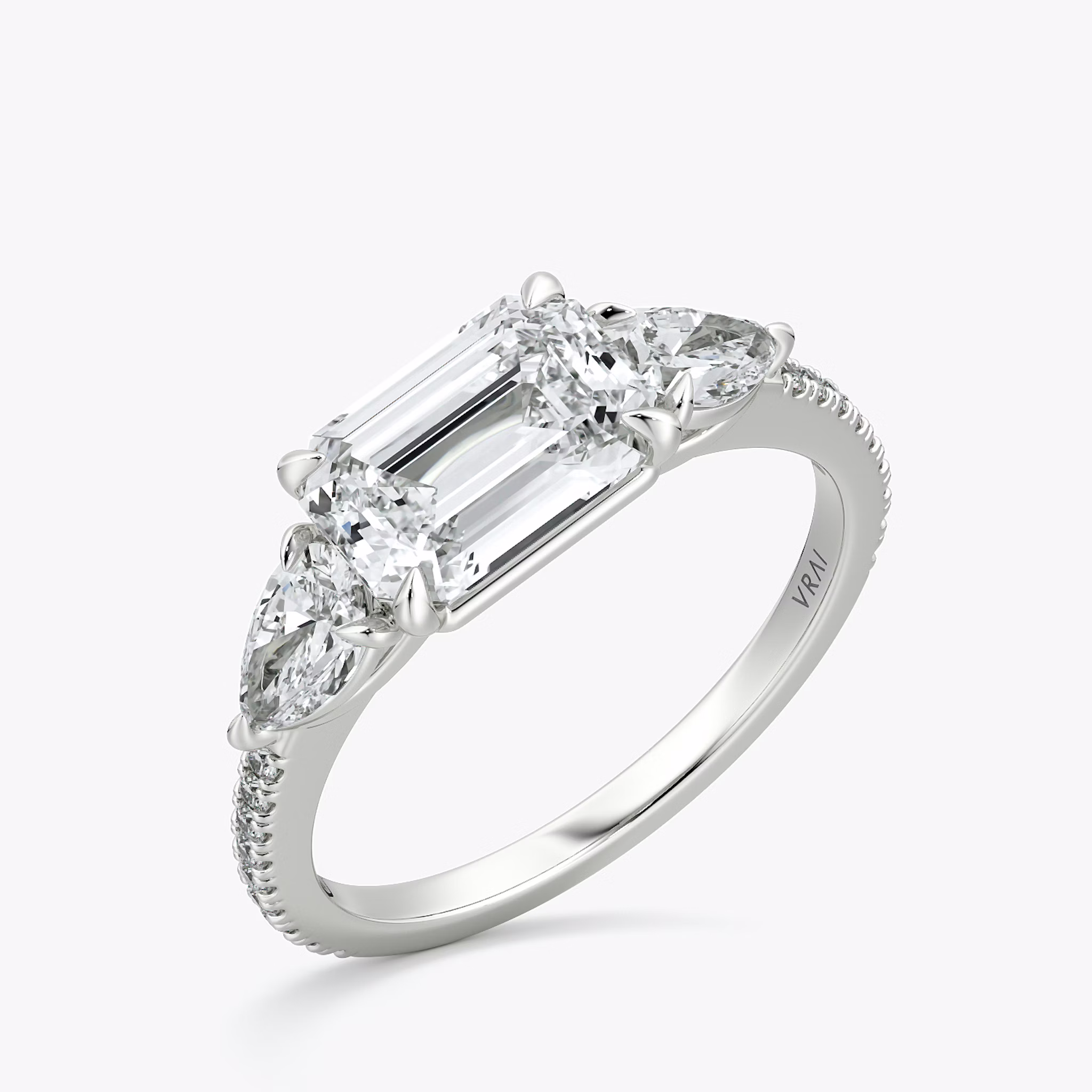 The Three Stone | Emerald | Platinum | bandAccent: Pavé | diamondOrientation: horizontal | sideStoneCarat: 0.25ct | sideStoneShape: Pear | caratWeight: other