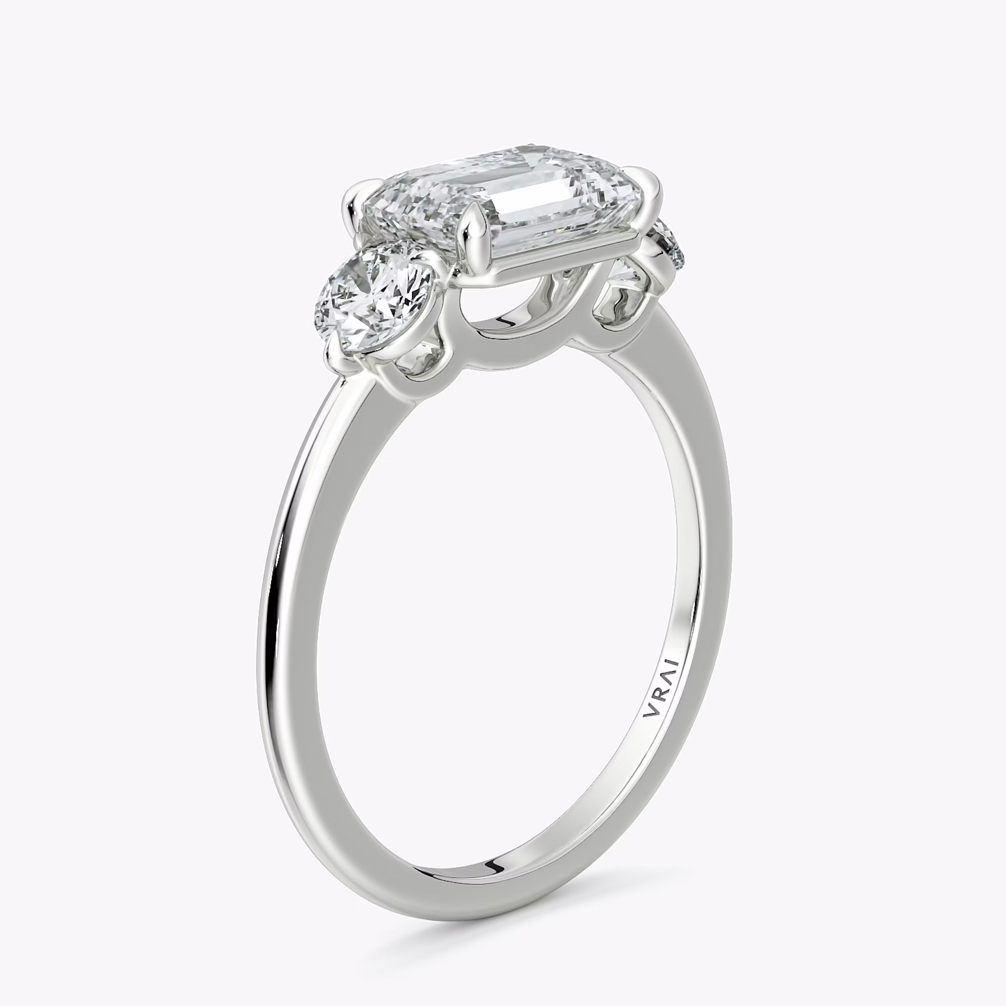 The Three Stone | Emerald | 18k | White Gold | bandAccent: Plain | diamondOrientation: horizontal | sideStoneCarat: 0.25ct | sideStoneShape: Round Brilliant | caratWeight: other