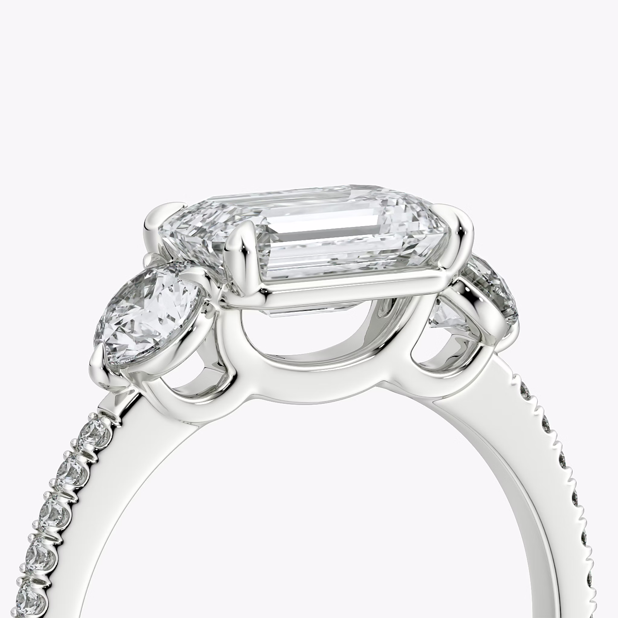 The Three Stone | Emerald | Platinum | bandAccent: Pavé | diamondOrientation: horizontal | sideStoneCarat: 0.25ct | sideStoneShape: Round Brilliant | caratWeight: other