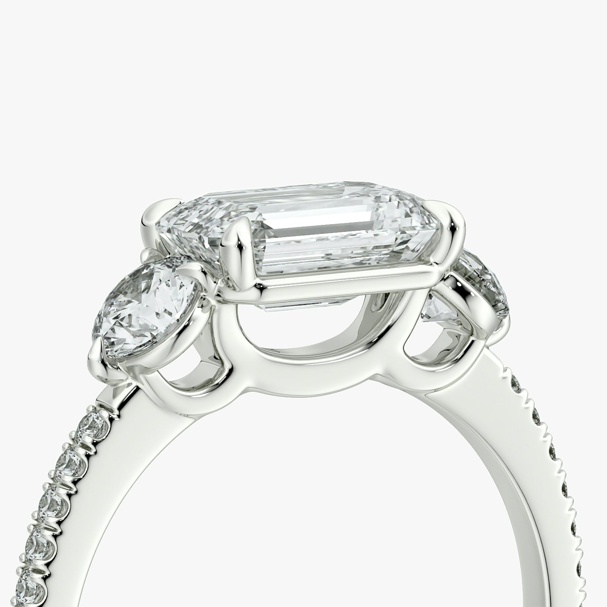 The Three Stone | Emerald | Platinum | bandAccent: Pavé | diamondOrientation: horizontal | sideStoneCarat: 0.25ct | sideStoneShape: Round Brilliant | caratWeight: other