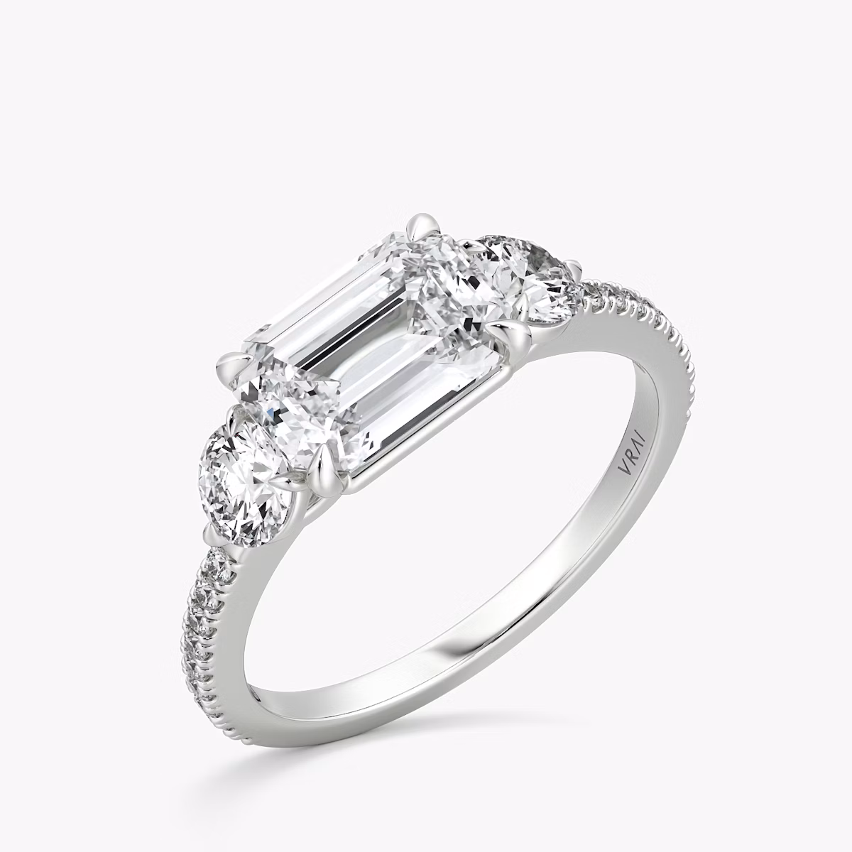 The Three Stone | Emerald | Platinum | bandAccent: Pavé | diamondOrientation: horizontal | sideStoneCarat: 0.25ct | sideStoneShape: Round Brilliant | caratWeight: other