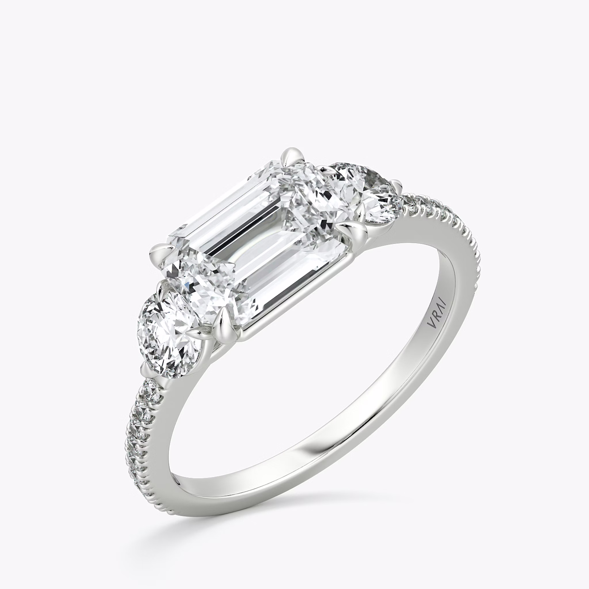 The Three Stone | Emerald | Platinum | bandAccent: Pavé | diamondOrientation: horizontal | sideStoneCarat: 0.25ct | sideStoneShape: Round Brilliant | caratWeight: other