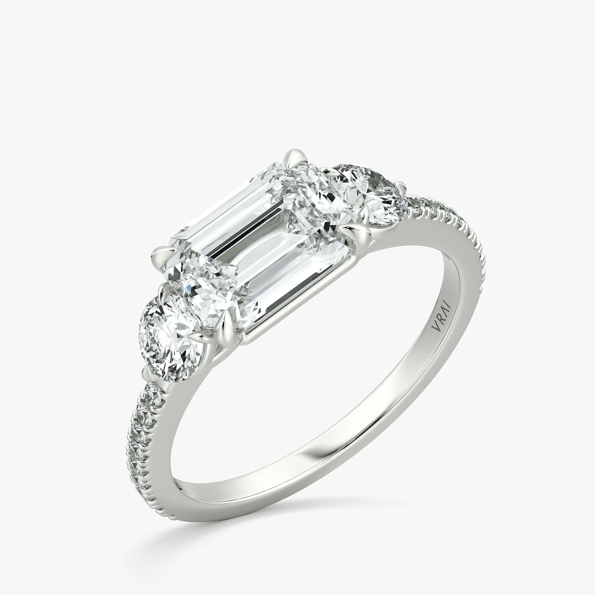 The Three Stone | Emerald | Platinum | bandAccent: Pavé | diamondOrientation: horizontal | sideStoneCarat: 0.25ct | sideStoneShape: Round Brilliant | caratWeight: other