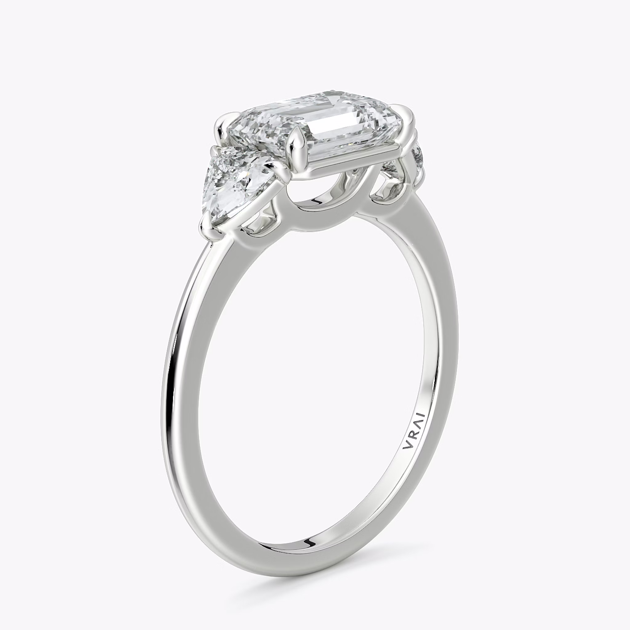 The Three Stone | Emerald | 18k | White Gold | bandAccent: Plain | diamondOrientation: horizontal | sideStoneCarat: 0.25ct | sideStoneShape: Trillion | caratWeight: other