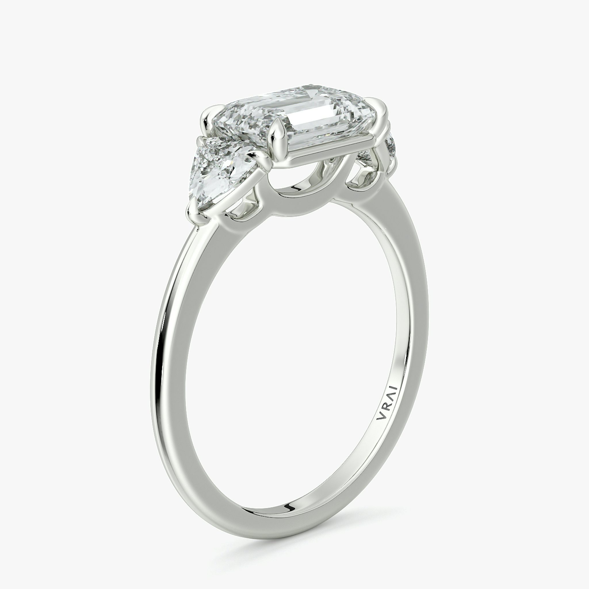 The Three Stone | Emerald | 18k | White Gold | bandAccent: Plain | diamondOrientation: horizontal | sideStoneCarat: 0.25ct | sideStoneShape: Trillion | caratWeight: other