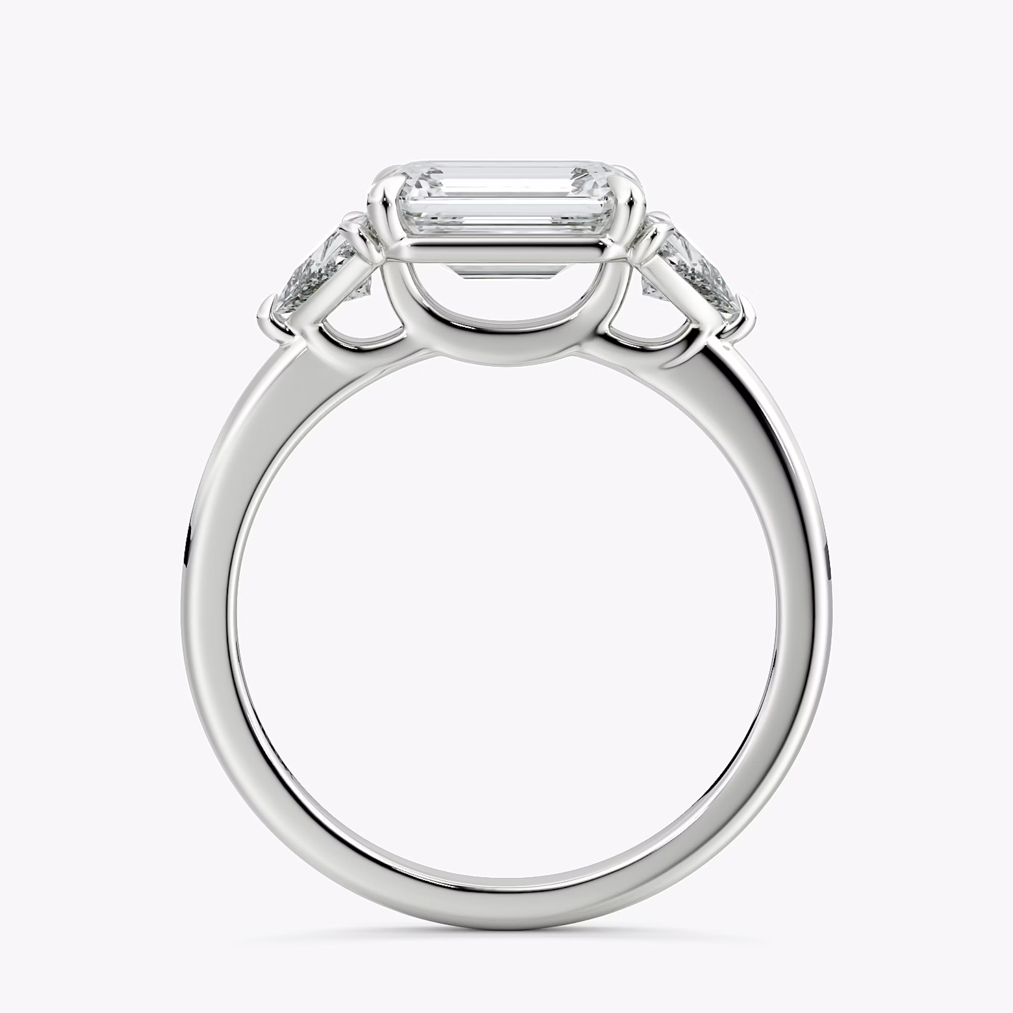 The Three Stone | Emerald | 18k | White Gold | bandAccent: Plain | diamondOrientation: horizontal | sideStoneCarat: 0.25ct | sideStoneShape: Trillion | caratWeight: other