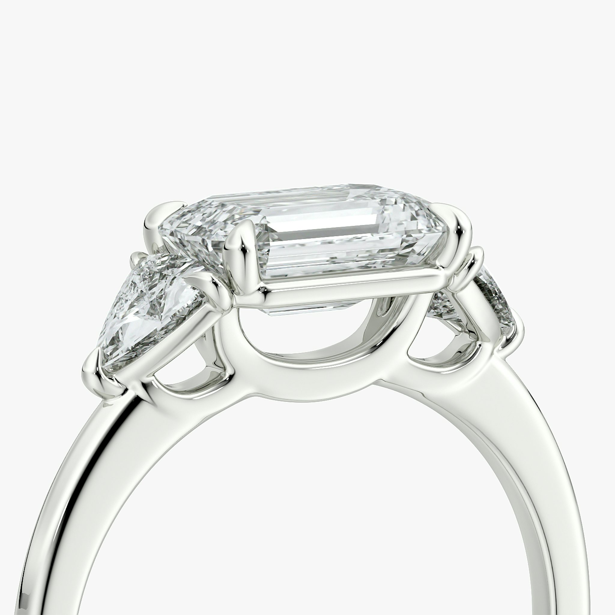 The Three Stone | Emerald | 18k | White Gold | bandAccent: Plain | diamondOrientation: horizontal | sideStoneCarat: 0.25ct | sideStoneShape: Trillion | caratWeight: other