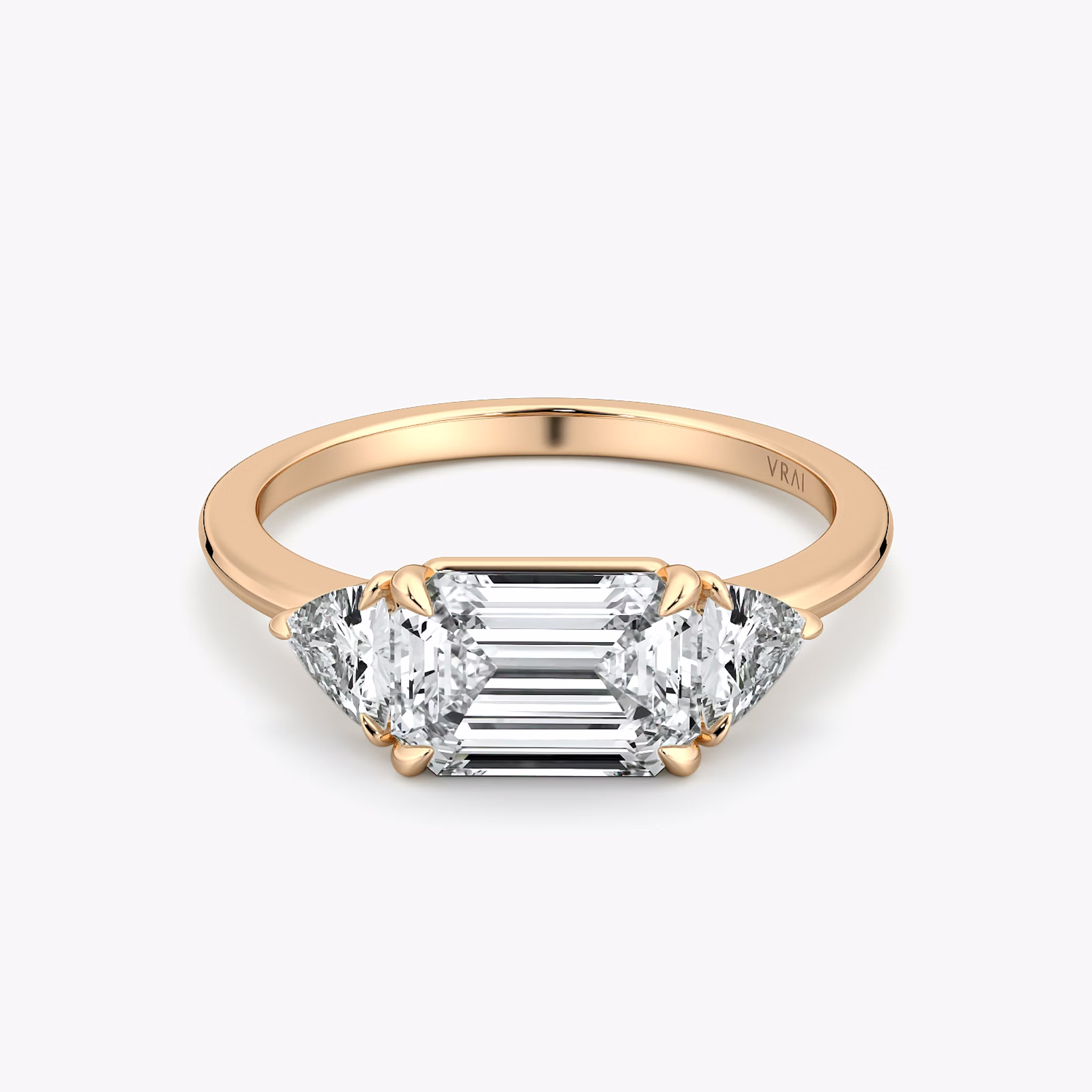 The Three Stone | Emerald | 14k | Rose Gold | bandAccent: Plain | diamondOrientation: horizontal | sideStoneCarat: 0.25ct | sideStoneShape: Trillion | caratWeight: other