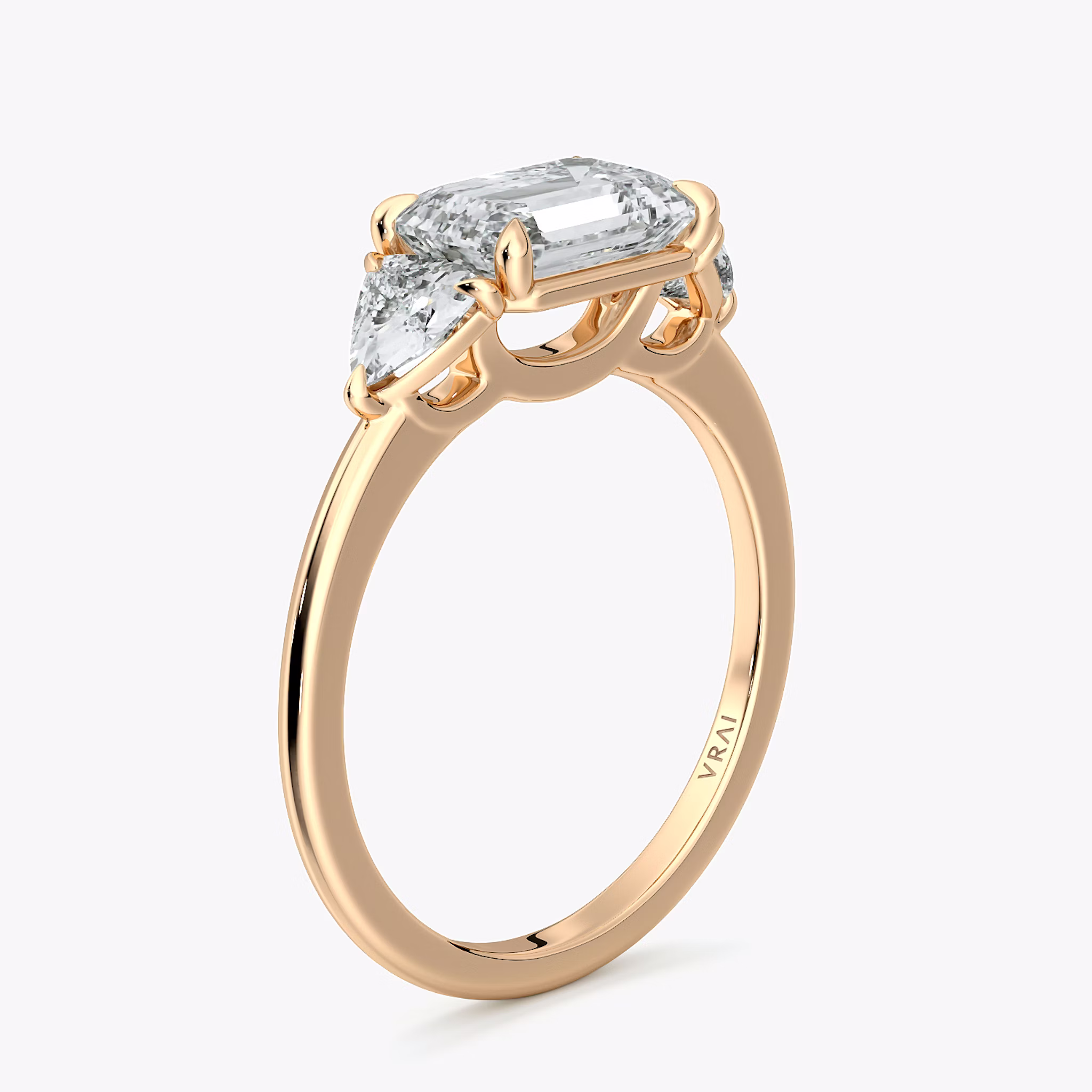The Three Stone | Emerald | 14k | Rose Gold | bandAccent: Plain | diamondOrientation: horizontal | sideStoneCarat: 0.25ct | sideStoneShape: Trillion | caratWeight: other