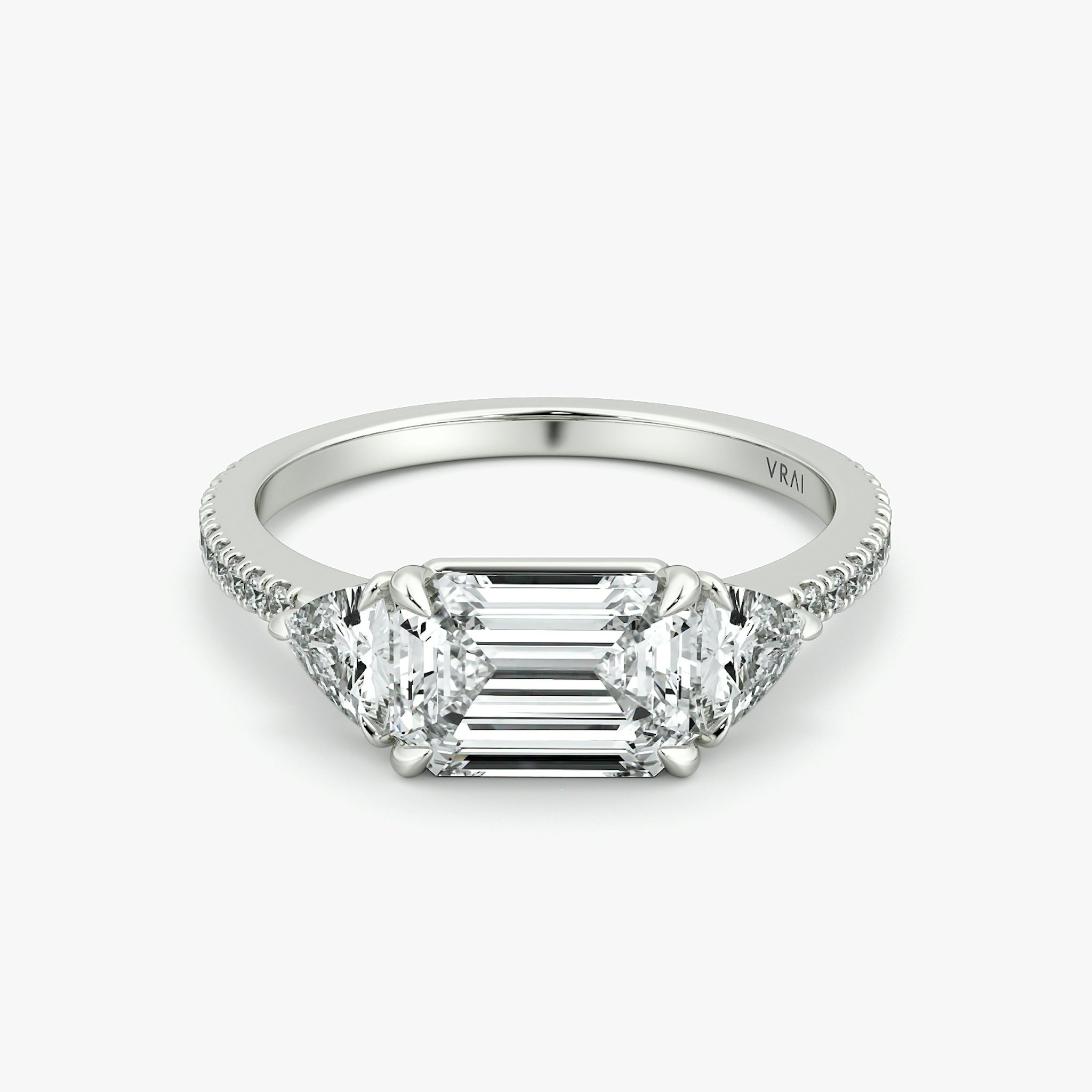 The Three Stone | Emerald | Platinum | bandAccent: Pavé | diamondOrientation: horizontal | sideStoneCarat: 0.25ct | sideStoneShape: Trillion | caratWeight: other