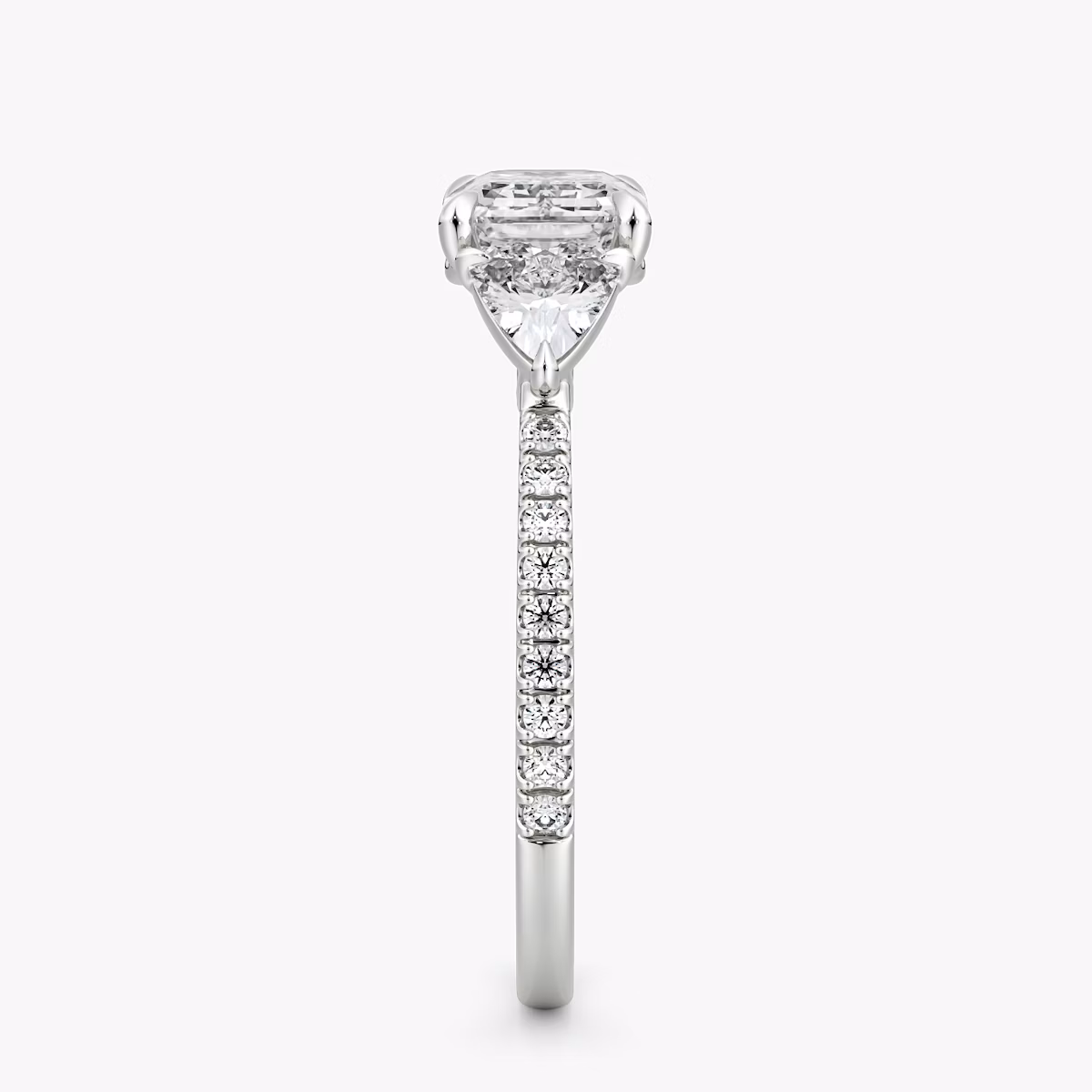 The Three Stone | Emerald | Platinum | bandAccent: Pavé | diamondOrientation: horizontal | sideStoneCarat: 0.25ct | sideStoneShape: Trillion | caratWeight: other