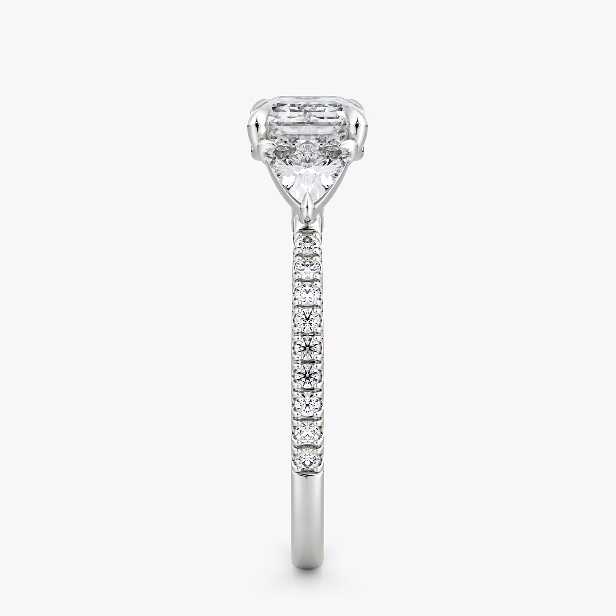 The Three Stone | Emerald | Platinum | bandAccent: Pavé | diamondOrientation: horizontal | sideStoneCarat: 0.25ct | sideStoneShape: Trillion | caratWeight: other