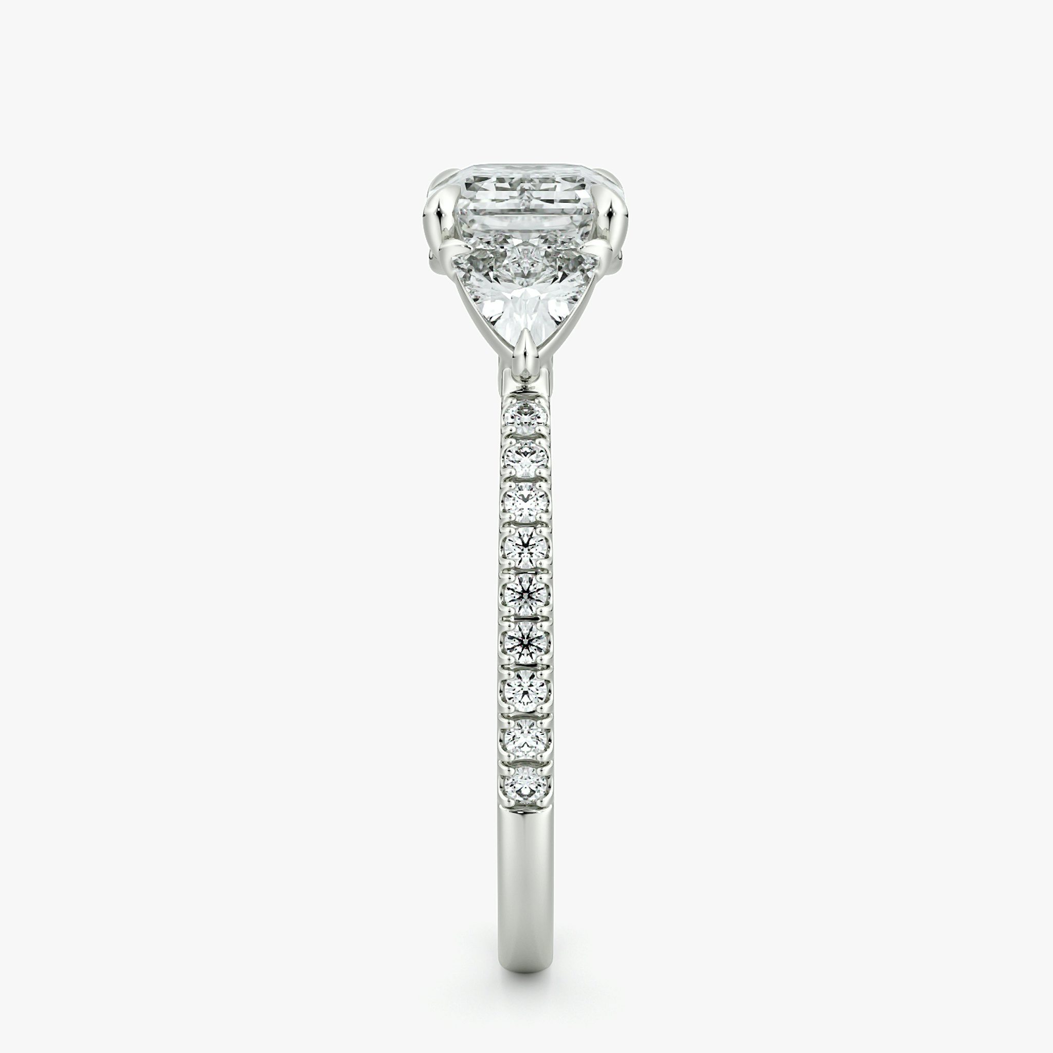 The Three Stone | Emerald | Platinum | bandAccent: Pavé | diamondOrientation: horizontal | sideStoneCarat: 0.25ct | sideStoneShape: Trillion | caratWeight: other