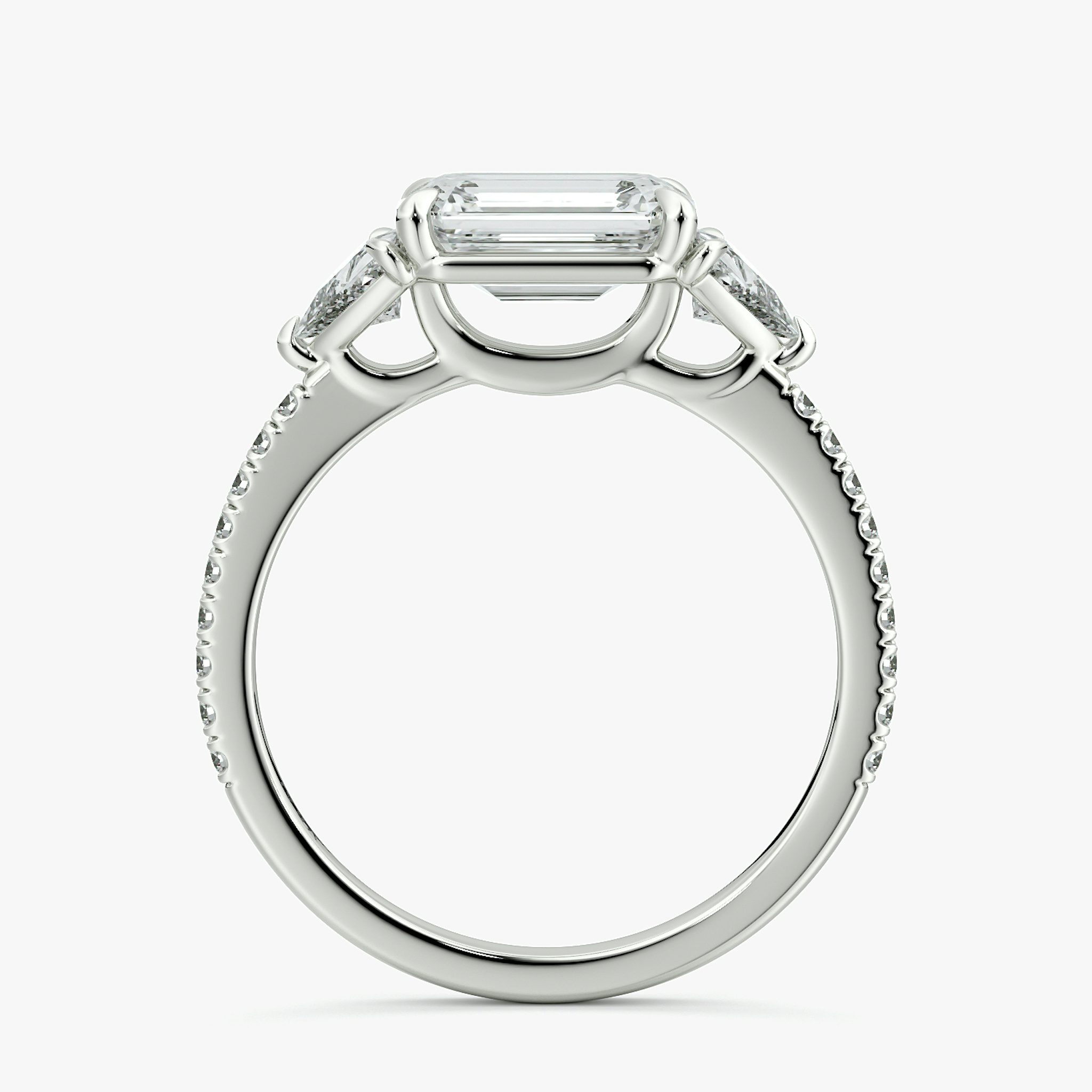 The Three Stone | Emerald | Platinum | bandAccent: Pavé | diamondOrientation: horizontal | sideStoneCarat: 0.25ct | sideStoneShape: Trillion | caratWeight: other