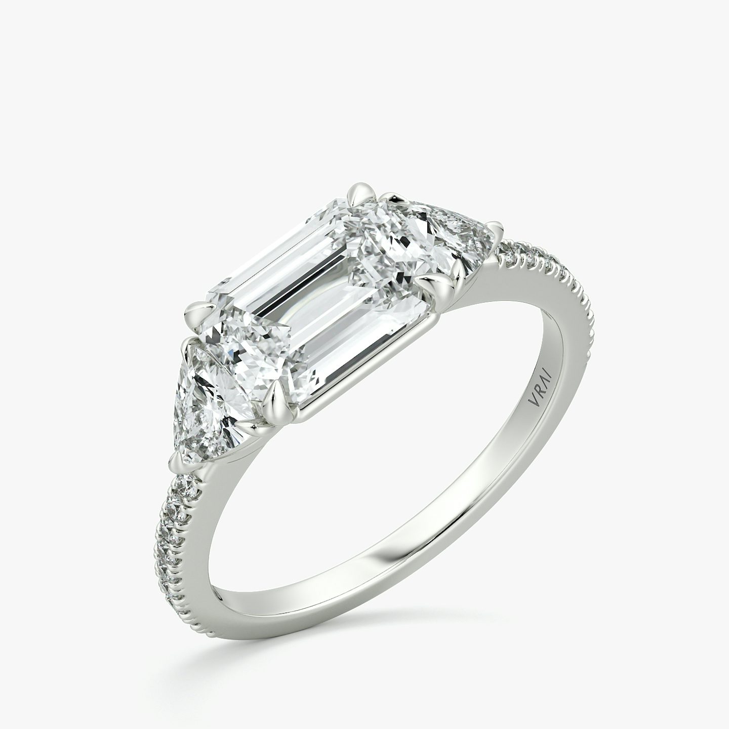 The Three Stone | Emerald | 18k | White Gold | bandAccent: Pavé | diamondOrientation: horizontal | sideStoneCarat: 0.25ct | sideStoneShape: Trillion | caratWeight: other