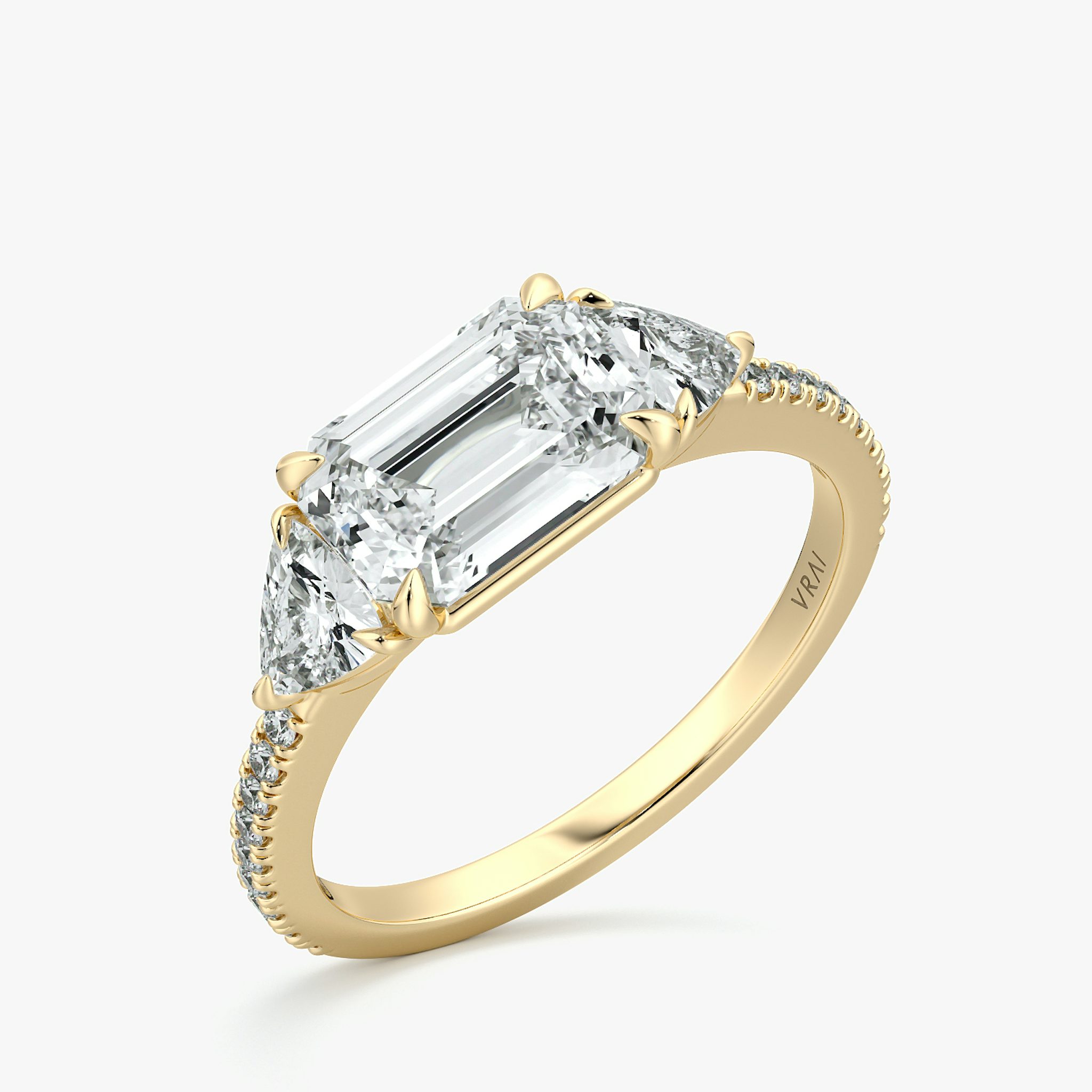 The Three Stone | Emerald | 18k | Yellow Gold | bandAccent: Pavé | diamondOrientation: horizontal | sideStoneCarat: 0.25ct | sideStoneShape: Trillion | caratWeight: other