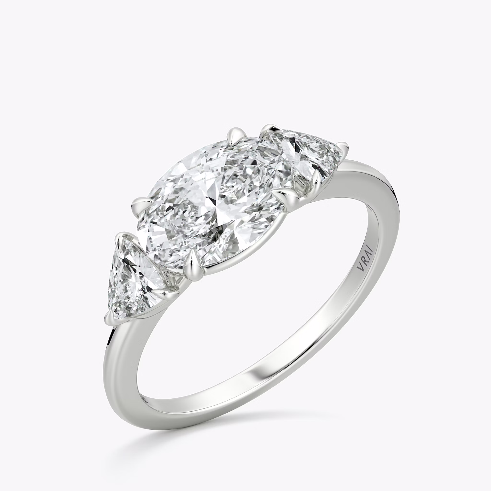 The Three Stone | Oval | 18k | White Gold | bandAccent: Plain | diamondOrientation: horizontal | sideStoneCarat: 0.25ct | sideStoneShape: Trillion | caratWeight: other