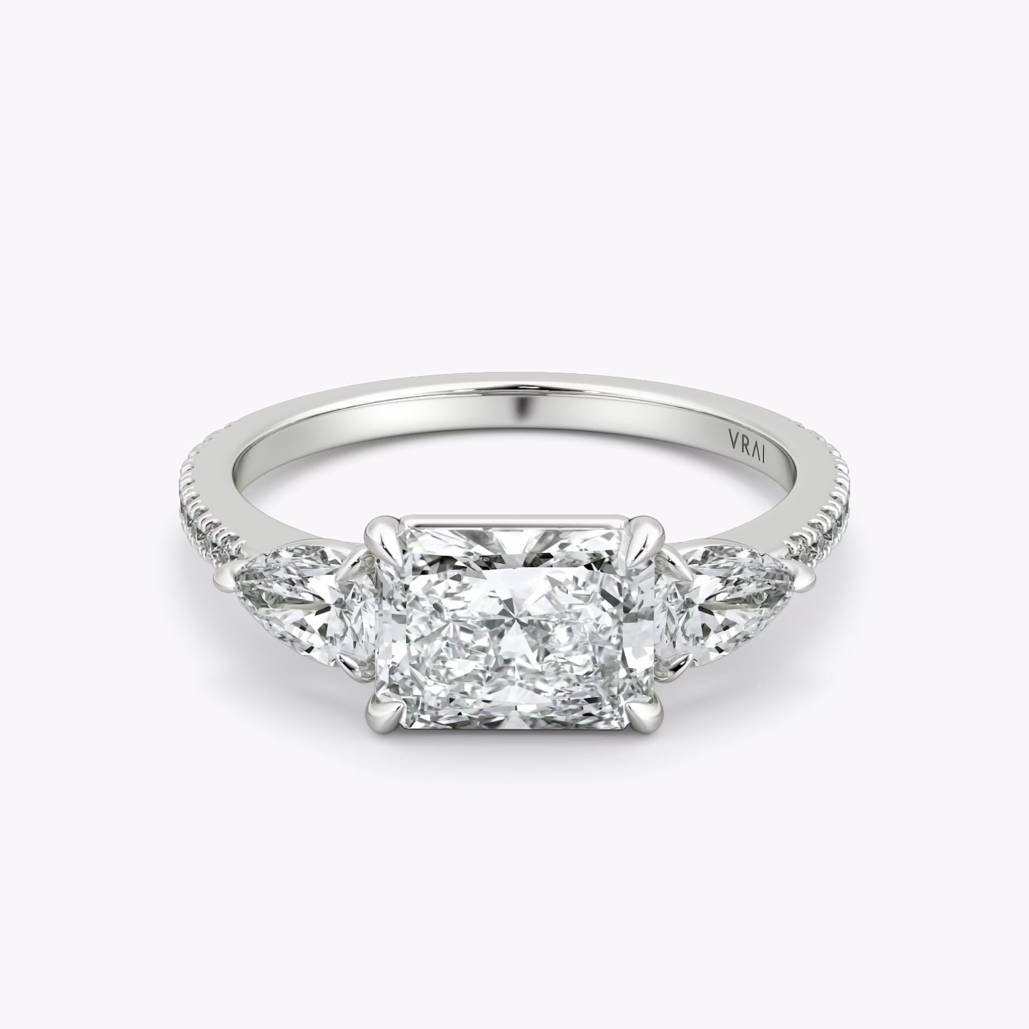 The Three Stone | Radiant | 18k | White Gold | bandAccent: Pavé | diamondOrientation: horizontal | sideStoneCarat: 0.25ct | sideStoneShape: Pear | caratWeight: other