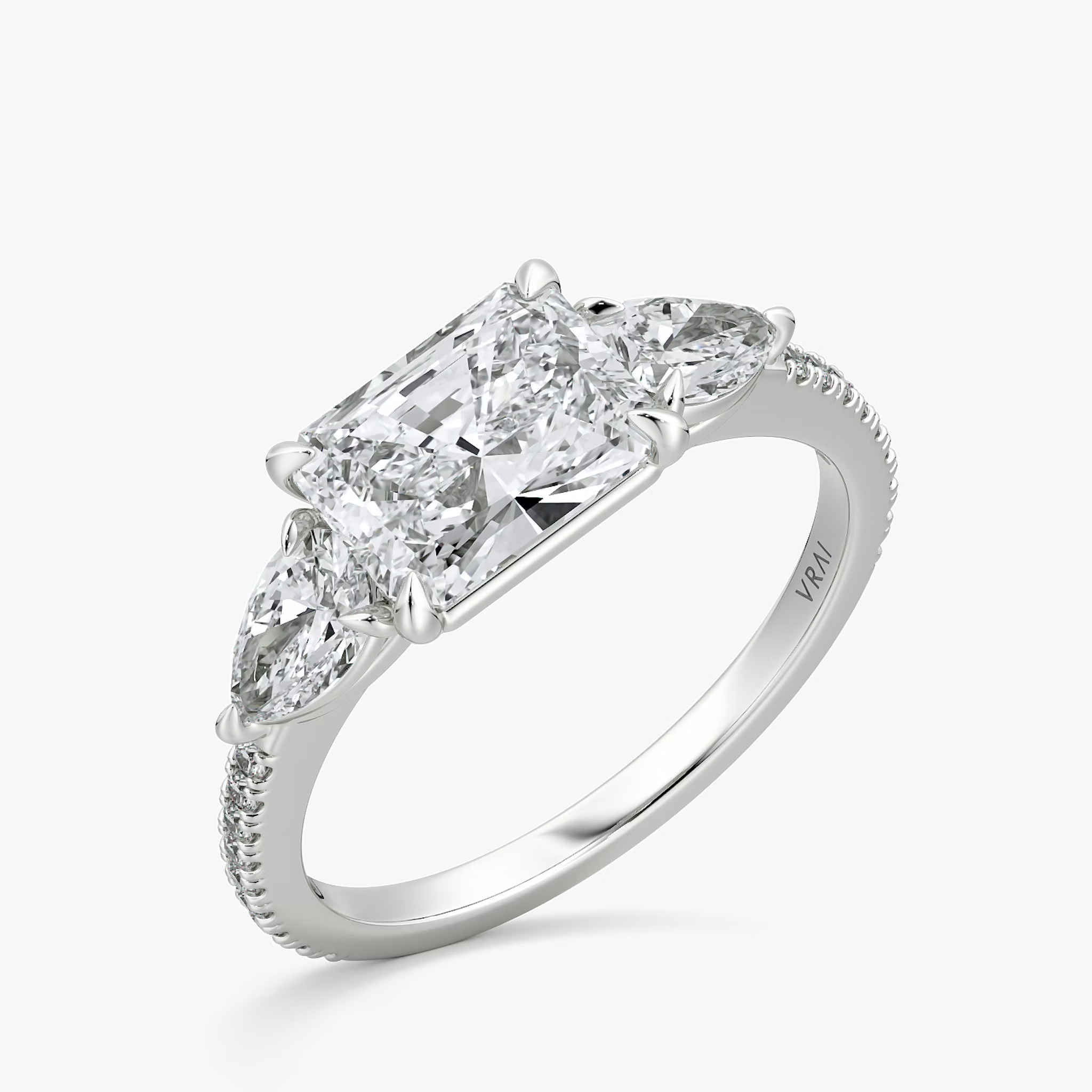 The Three Stone | Radiant | 18k | White Gold | bandAccent: Pavé | diamondOrientation: horizontal | sideStoneCarat: 0.25ct | sideStoneShape: Pear | caratWeight: other