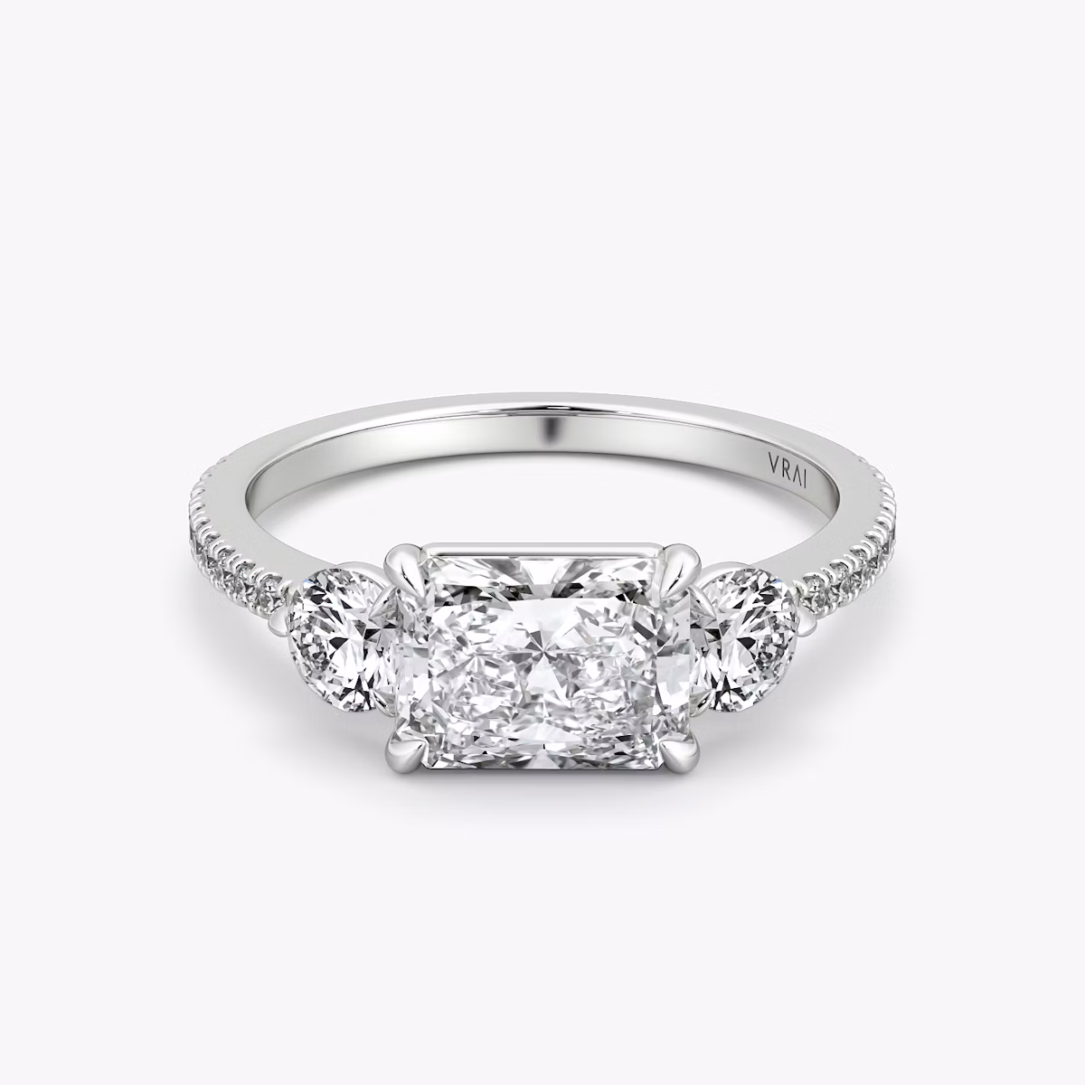 The Three Stone | Radiant | 18k | White Gold | bandAccent: Pavé | diamondOrientation: horizontal | sideStoneCarat: 0.25ct | sideStoneShape: Round Brilliant | caratWeight: other