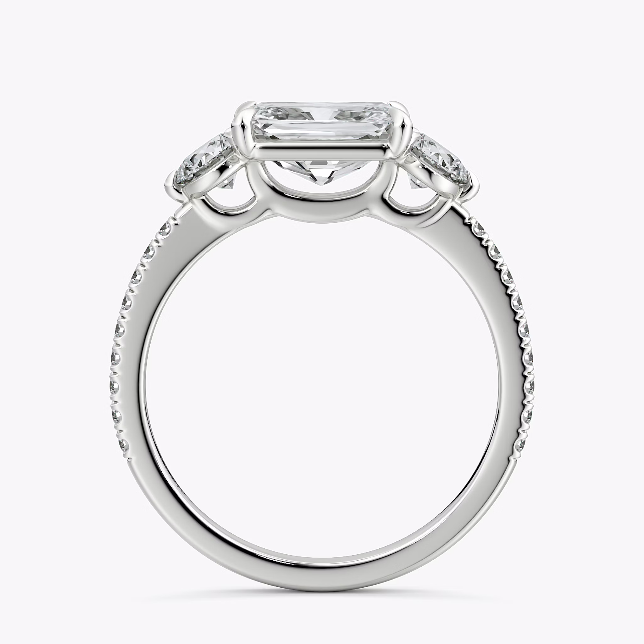 The Three Stone | Radiant | 18k | White Gold | bandAccent: Pavé | diamondOrientation: horizontal | sideStoneCarat: 0.25ct | sideStoneShape: Round Brilliant | caratWeight: other