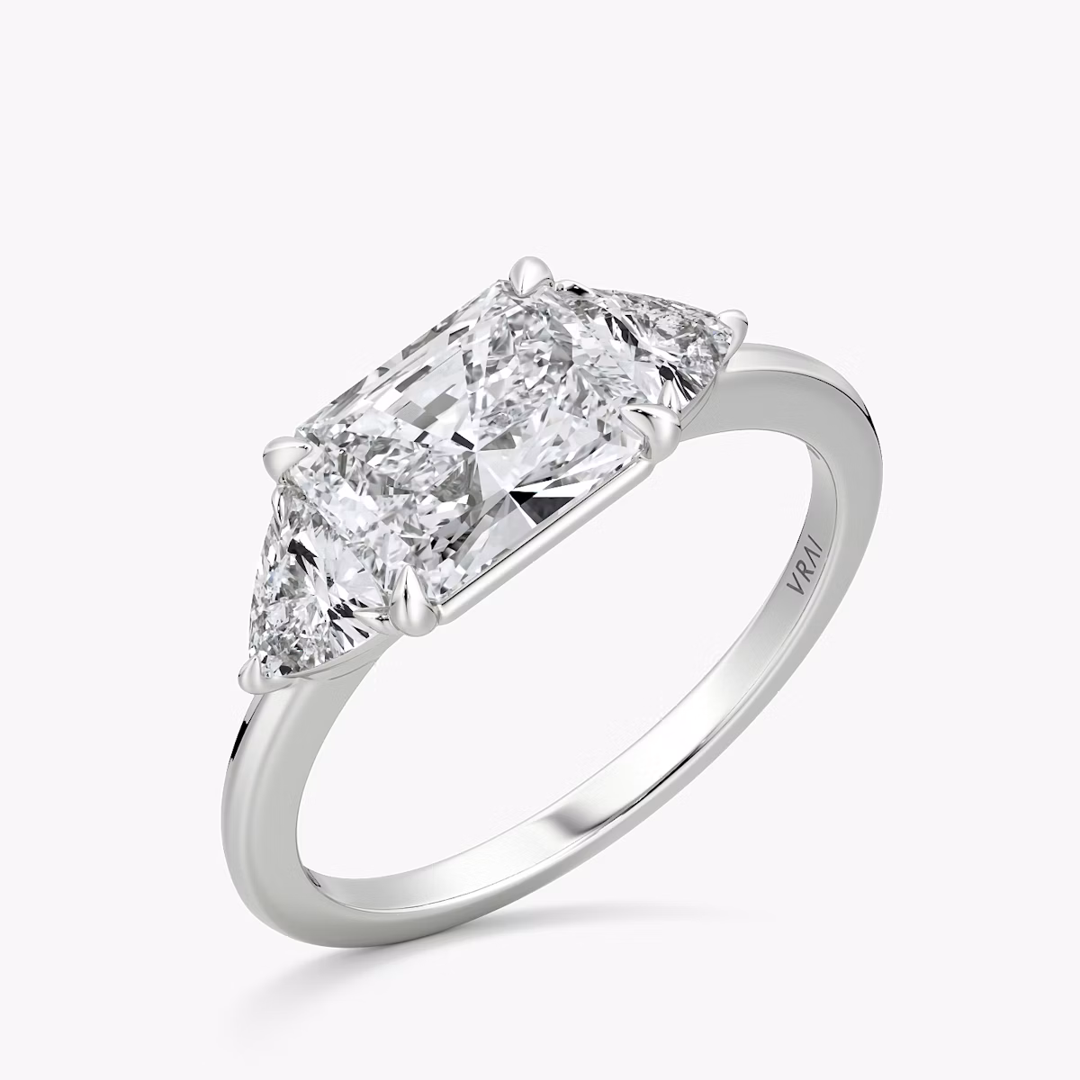 The Three Stone | Radiant | 18k | White Gold | bandAccent: Plain | diamondOrientation: horizontal | sideStoneCarat: 0.25ct | sideStoneShape: Trillion | caratWeight: other