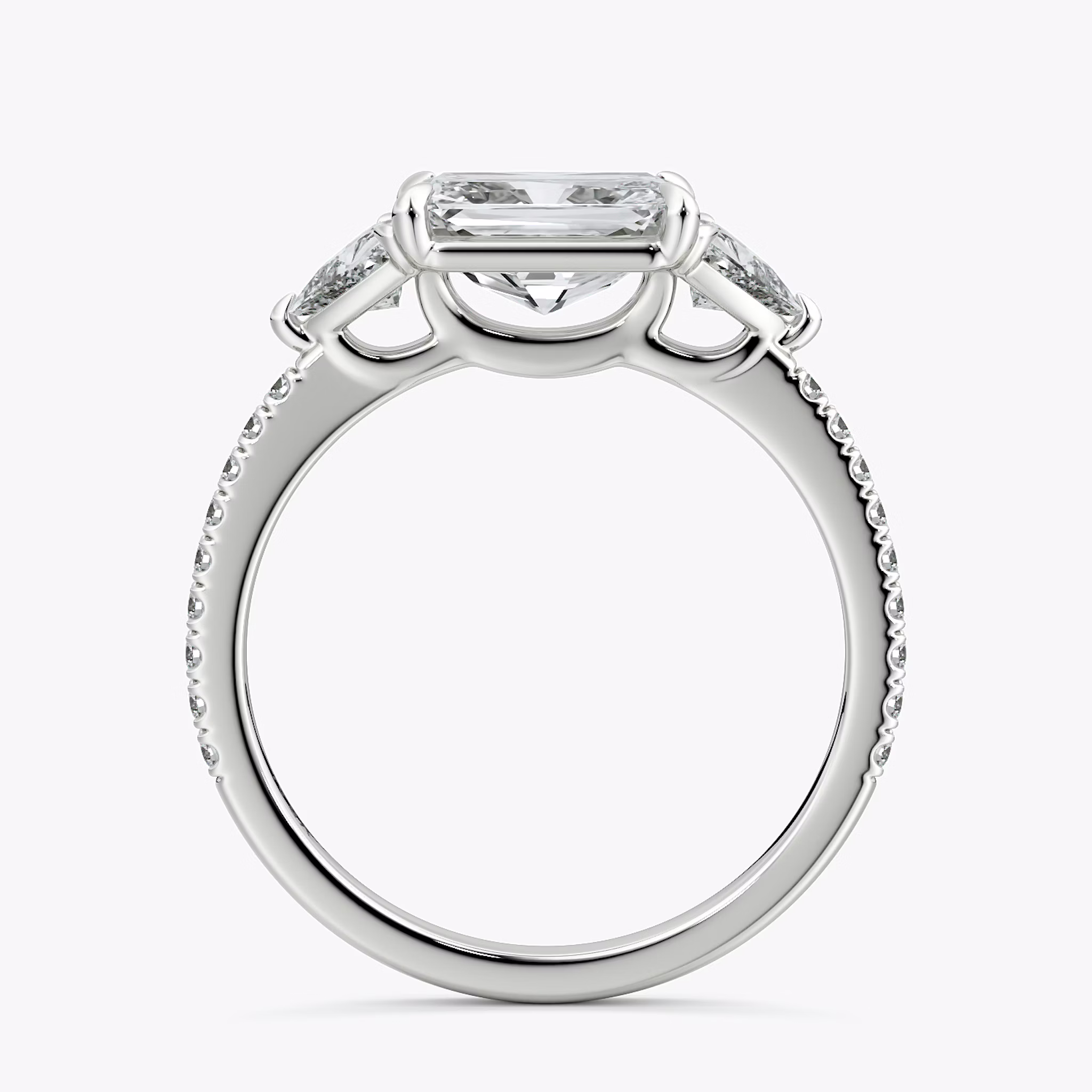 The Three Stone | Radiant | Platinum | bandAccent: Pavé | diamondOrientation: horizontal | sideStoneCarat: 0.25ct | sideStoneShape: Trillion | caratWeight: other