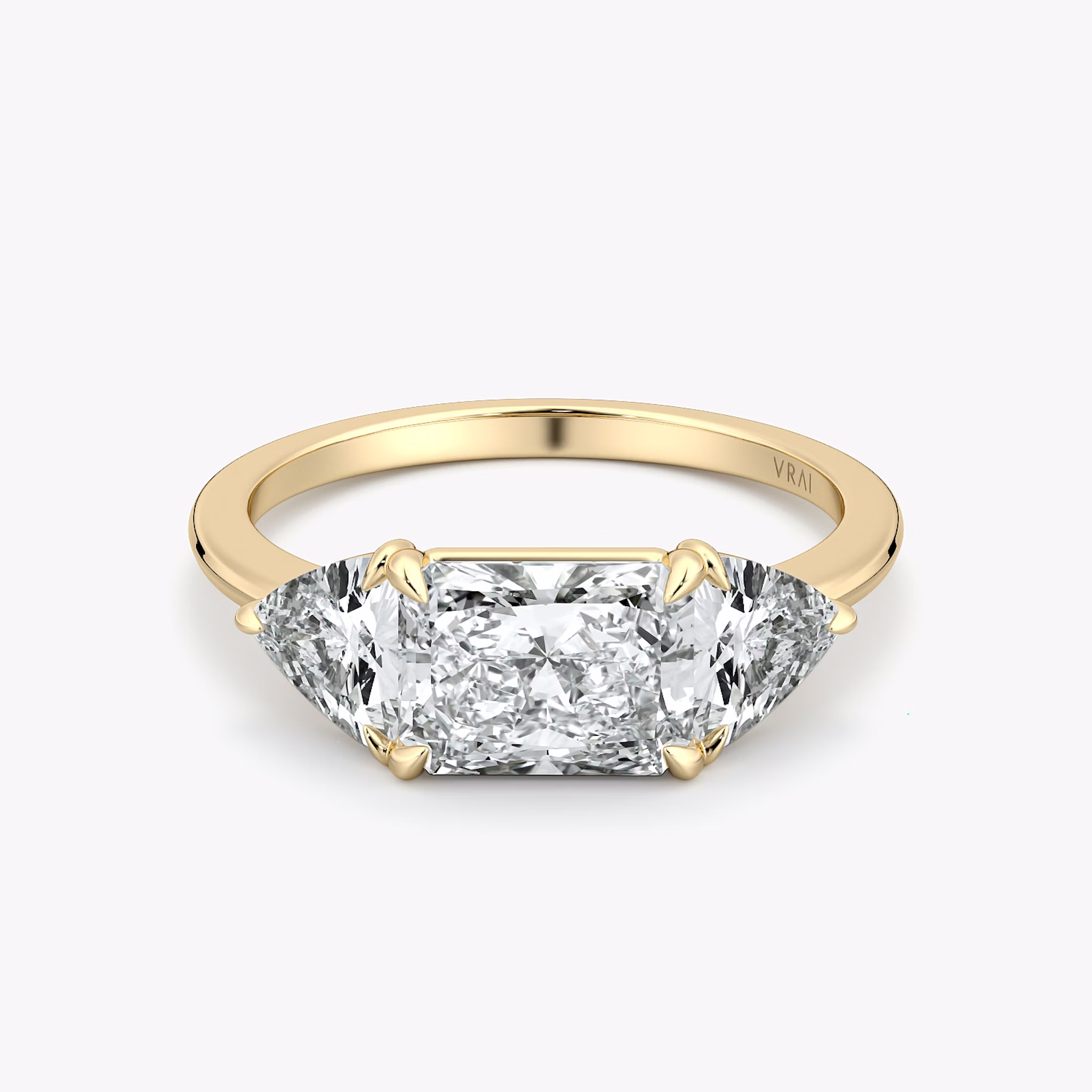 Radiant-cut and trillion-cut three-stone ring with plain yellow gold band, East-West 0.50ct setting.