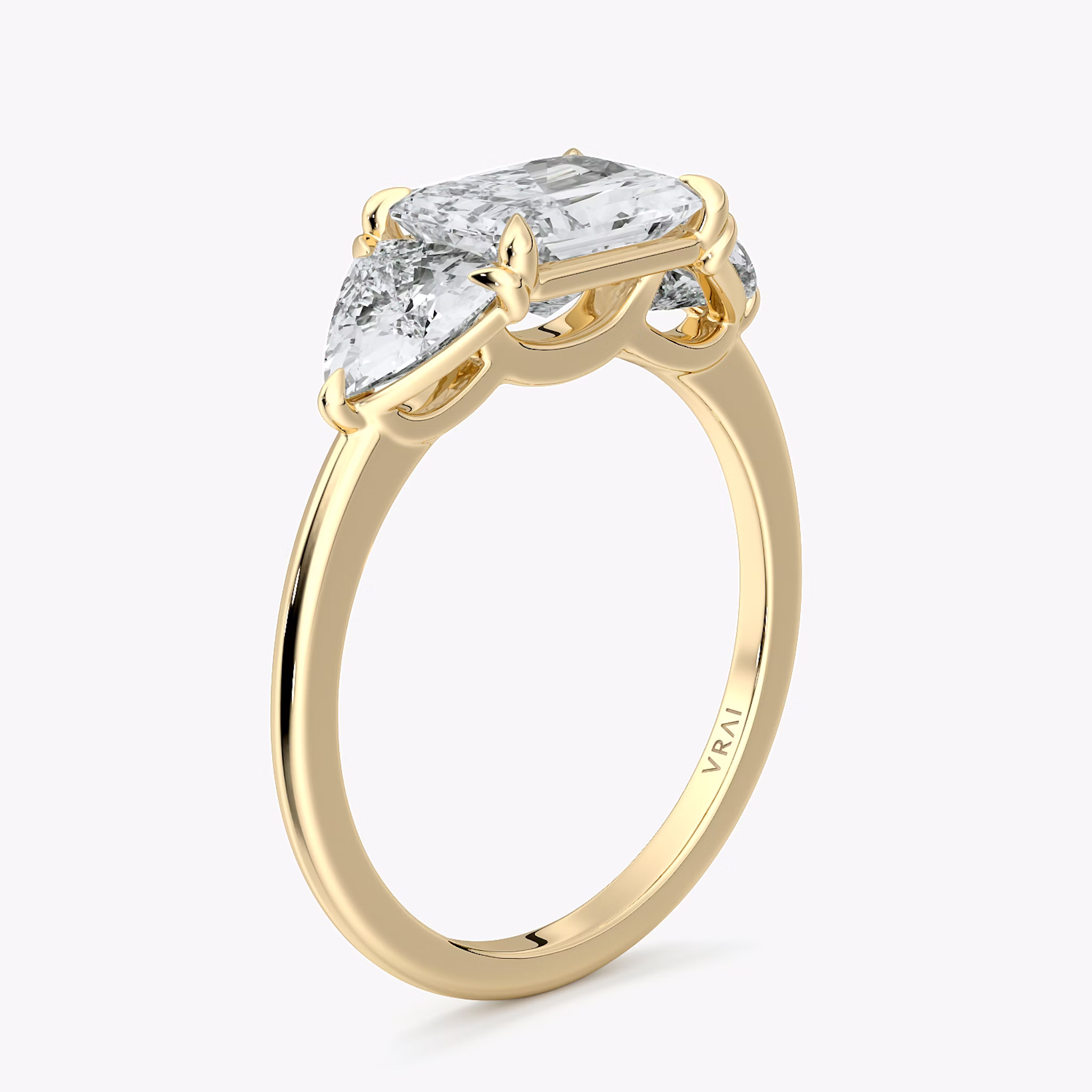 Radiant-cut and trillion-cut three-stone ring with plain yellow gold band, East-West 0.50ct setting.