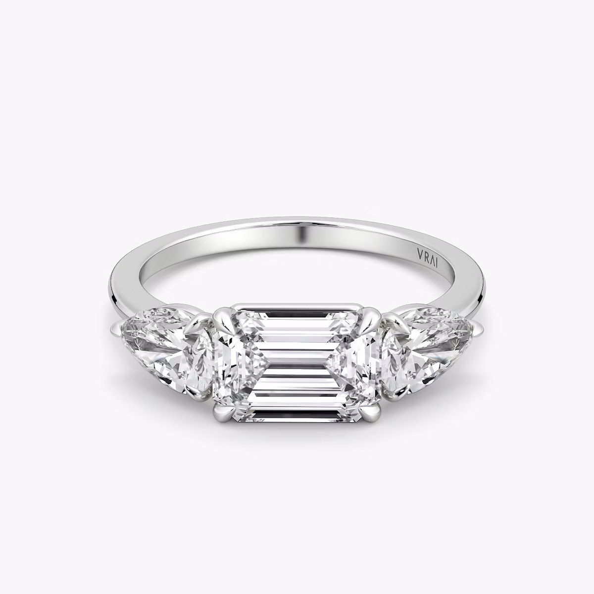 The Three Stone | Emerald | 18k | White Gold | bandAccent: Plain | diamondOrientation: horizontal | sideStoneCarat: 0.50ct | sideStoneShape: Pear | caratWeight: other