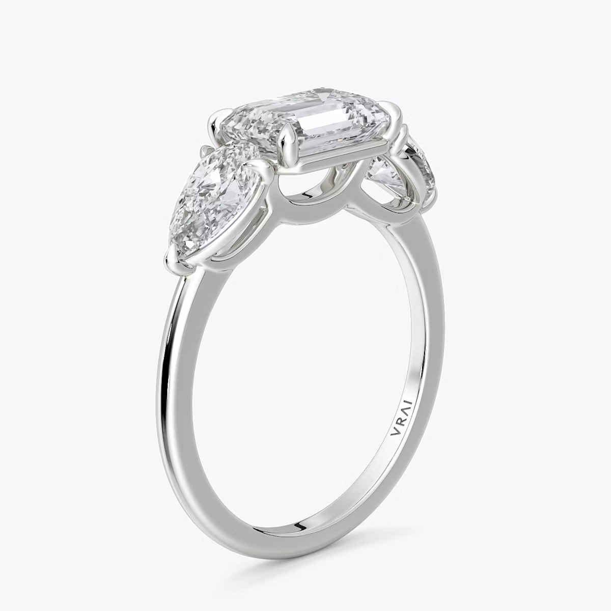The Three Stone | Emerald | 18k | White Gold | bandAccent: Plain | diamondOrientation: horizontal | sideStoneCarat: 0.50ct | sideStoneShape: Pear | caratWeight: other
