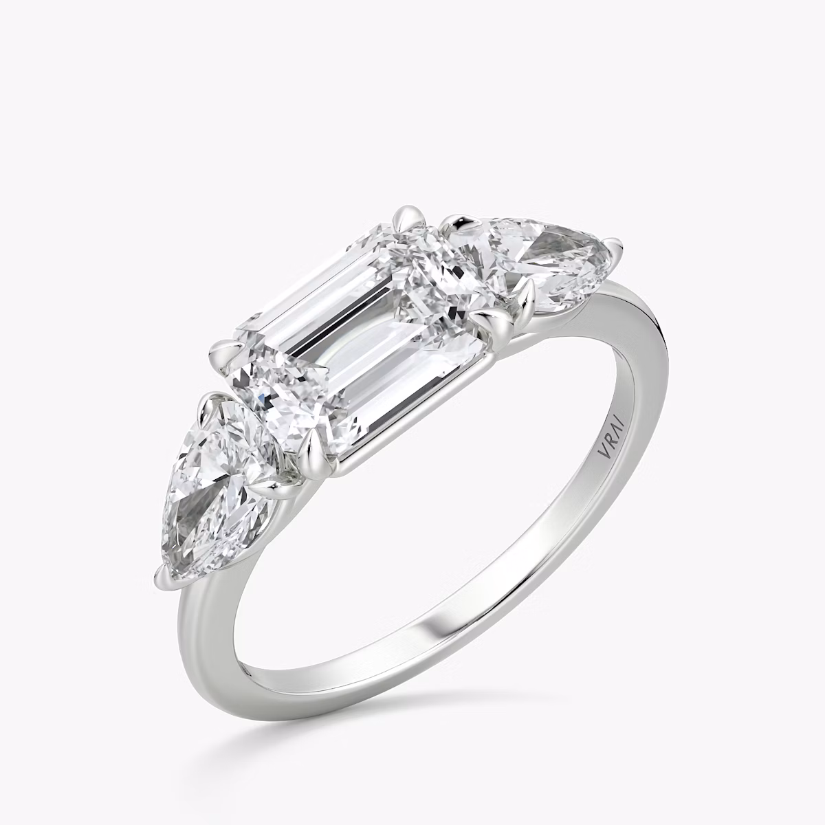 The Three Stone | Emerald | 18k | White Gold | bandAccent: Plain | diamondOrientation: horizontal | sideStoneCarat: 0.50ct | sideStoneShape: Pear | caratWeight: other
