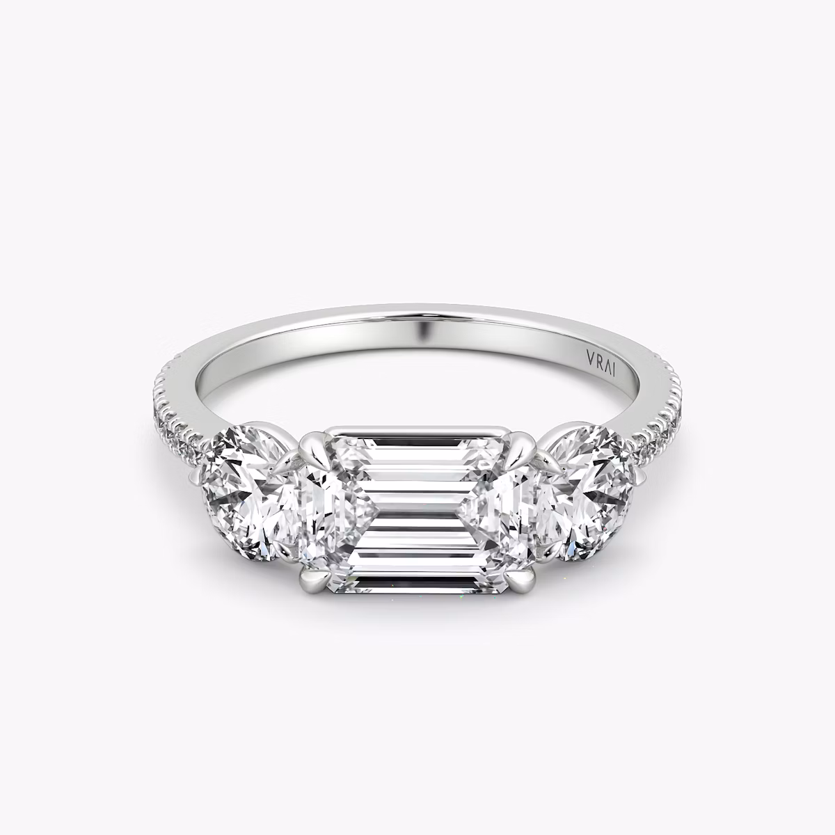 The Three Stone | Emerald | Platinum | bandAccent: Pavé | diamondOrientation: horizontal | sideStoneCarat: 0.50ct | sideStoneShape: Round Brilliant | caratWeight: other