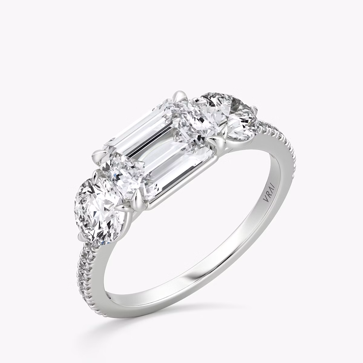 The Three Stone | Emerald | Platinum | bandAccent: Pavé | diamondOrientation: horizontal | sideStoneCarat: 0.50ct | sideStoneShape: Round Brilliant | caratWeight: other