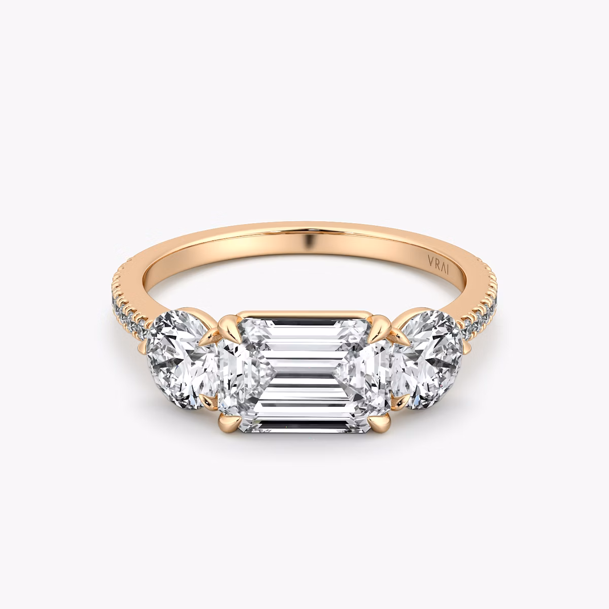 The Three Stone | Emerald | 14k | Rose Gold | bandAccent: Pavé | diamondOrientation: horizontal | sideStoneCarat: 0.50ct | sideStoneShape: Round Brilliant | caratWeight: other