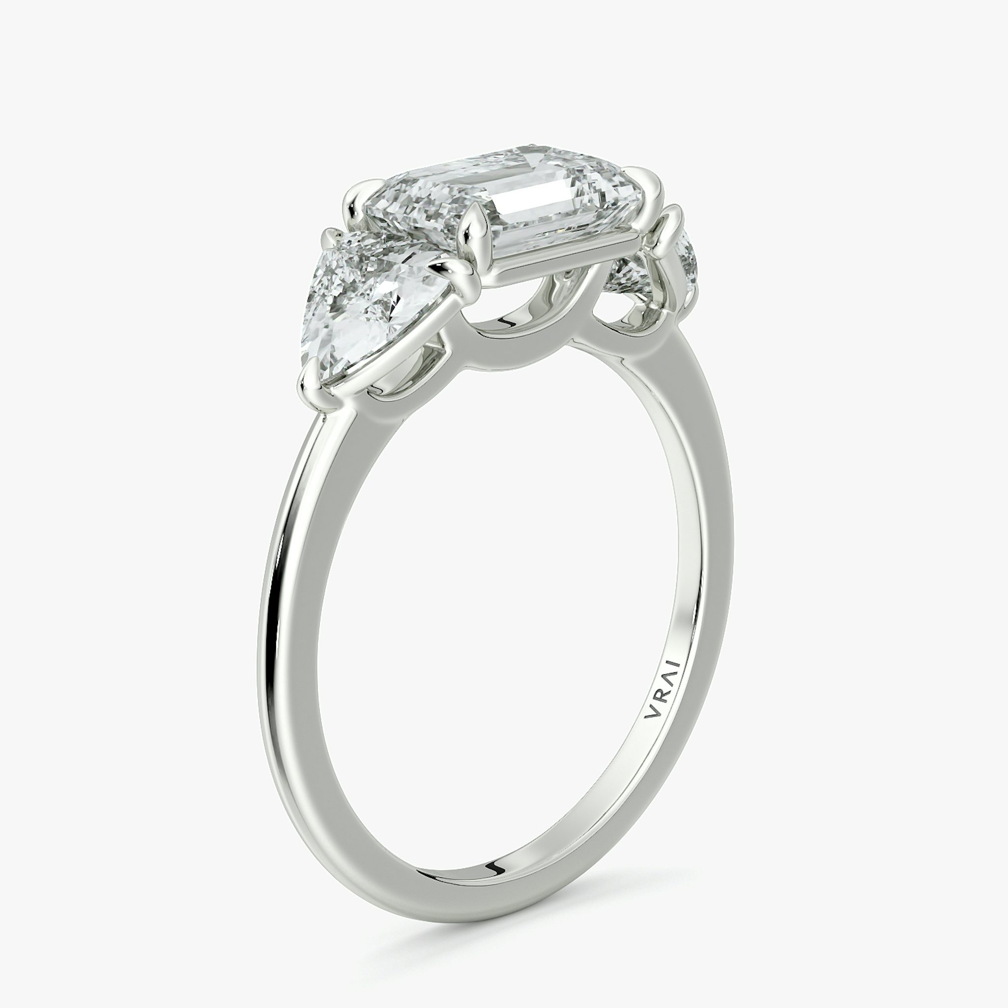 The Three Stone | Emerald | 18k | White Gold | bandAccent: Plain | diamondOrientation: horizontal | sideStoneCarat: 0.50ct | sideStoneShape: Trillion | caratWeight: other