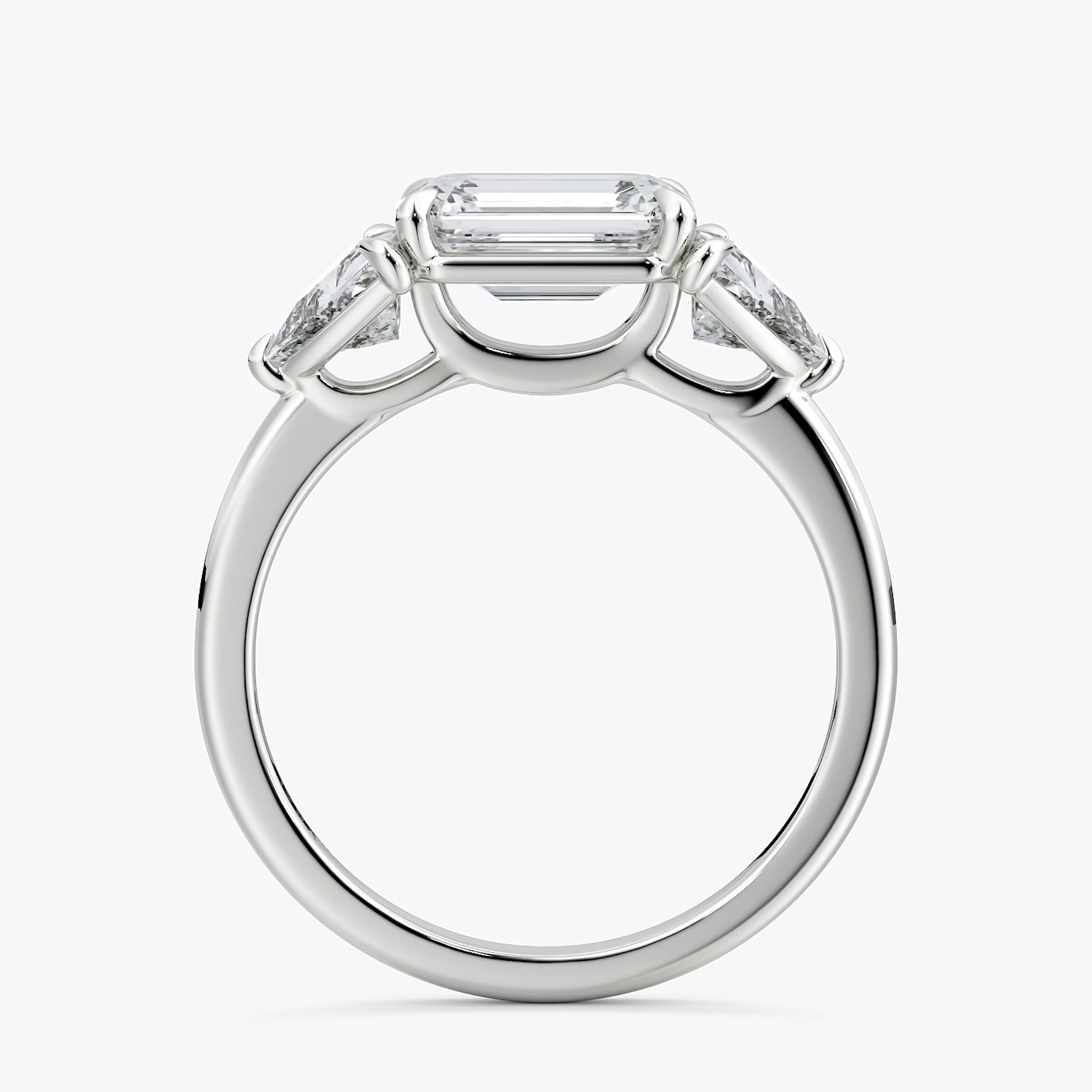 The Three Stone | Emerald | 18k | White Gold | bandAccent: Plain | diamondOrientation: horizontal | sideStoneCarat: 0.50ct | sideStoneShape: Trillion | caratWeight: other