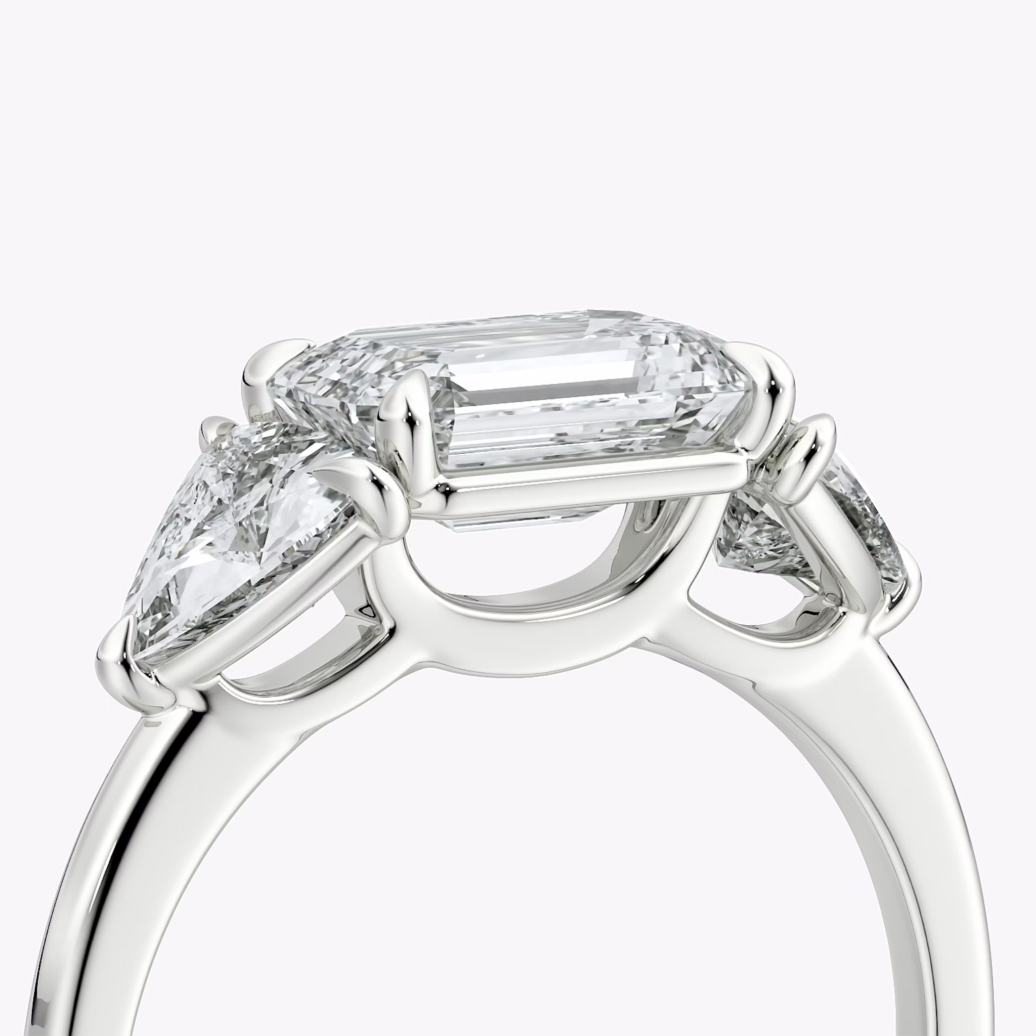 The Three Stone | Emerald | 18k | White Gold | bandAccent: Plain | diamondOrientation: horizontal | sideStoneCarat: 0.50ct | sideStoneShape: Trillion | caratWeight: other