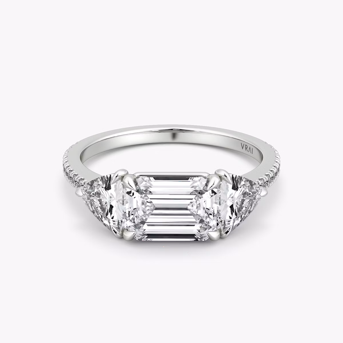 The Three Stone | Emerald | Platinum | bandAccent: Pavé | diamondOrientation: horizontal | sideStoneCarat: 0.50ct | sideStoneShape: Trillion | caratWeight: other