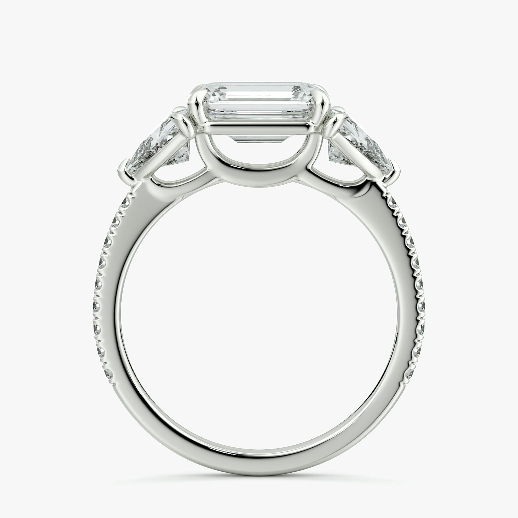 The Three Stone | Emerald | Platinum | bandAccent: Pavé | diamondOrientation: horizontal | sideStoneCarat: 0.50ct | sideStoneShape: Trillion | caratWeight: other