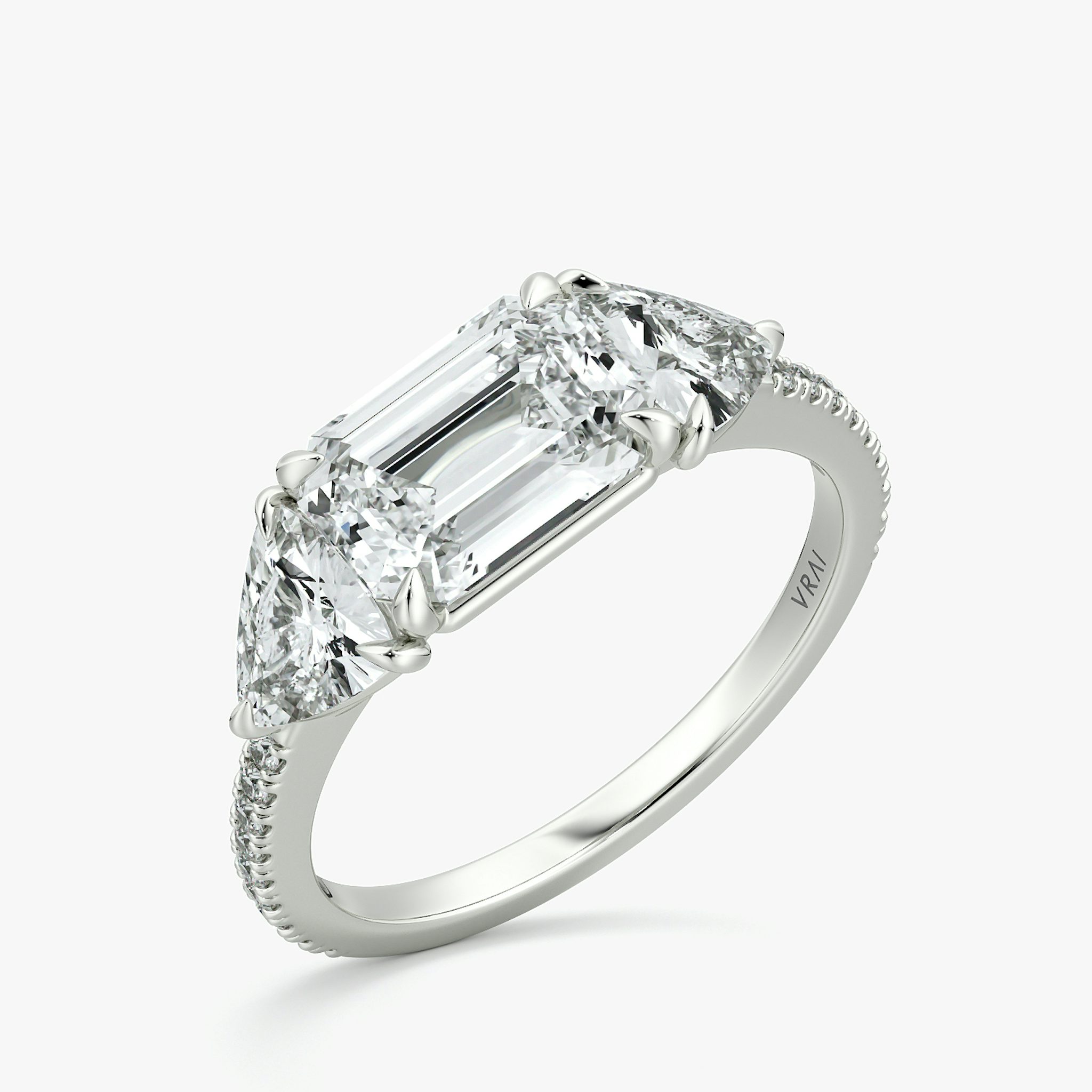 The Three Stone | Emerald | Platinum | bandAccent: Pavé | diamondOrientation: horizontal | sideStoneCarat: 0.50ct | sideStoneShape: Trillion | caratWeight: other