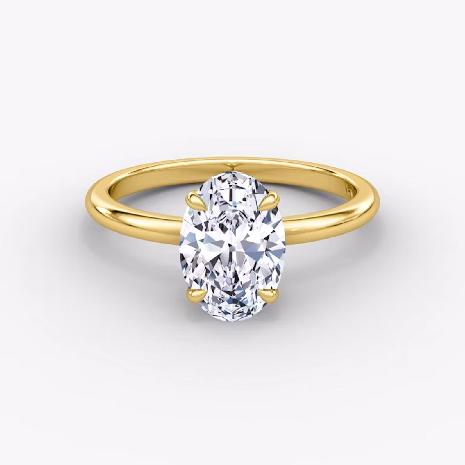 A close-up image of VRAI's Signature Oval Yellow Gold Engagement Ring, lying flat.