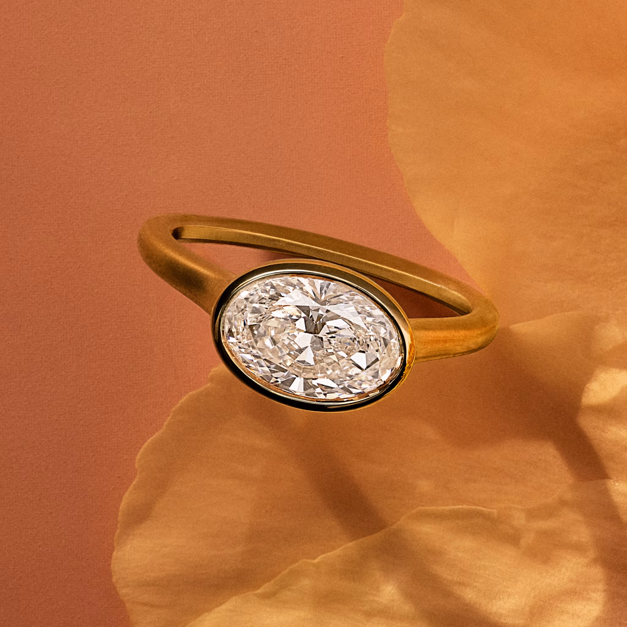 Anillo de compromiso oval biselado sobre pétalo de flor