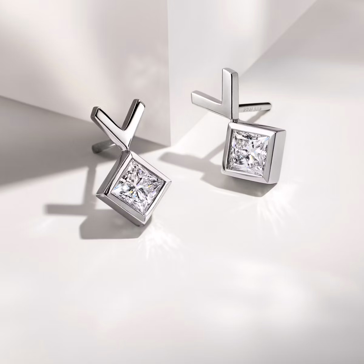 Pair of white gold stud earrings on a table