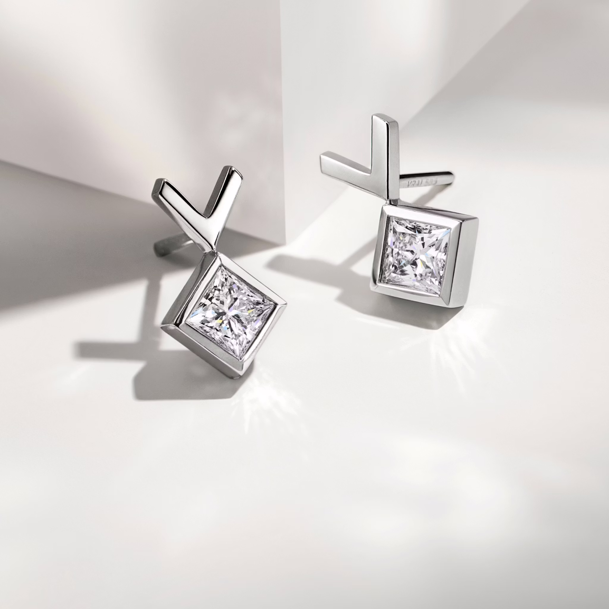 Pair of white gold stud earrings on a table