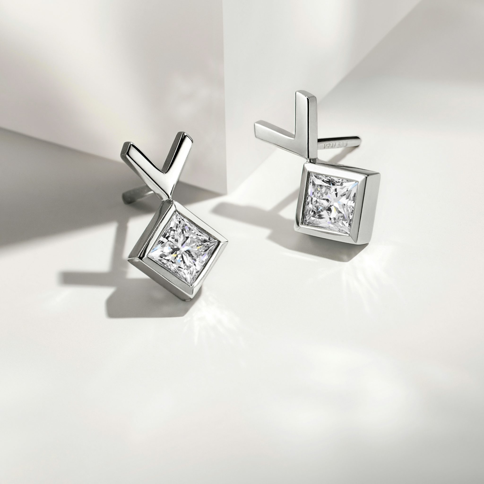 Pair of white gold stud earrings on a table